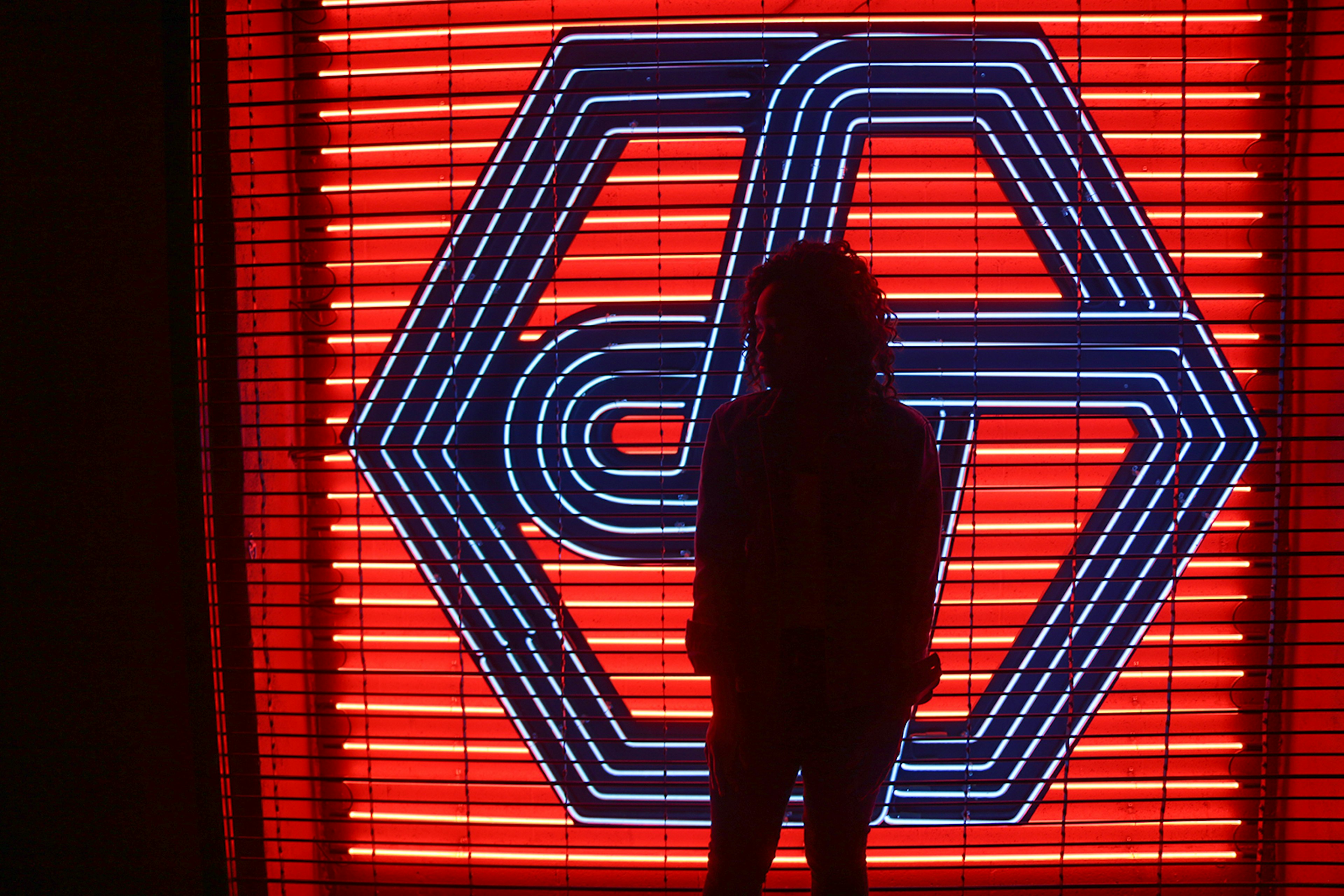 Woman in silhouette in front of a red and black neon sign © Ni'Kesia Pannell / ϲʼʱ