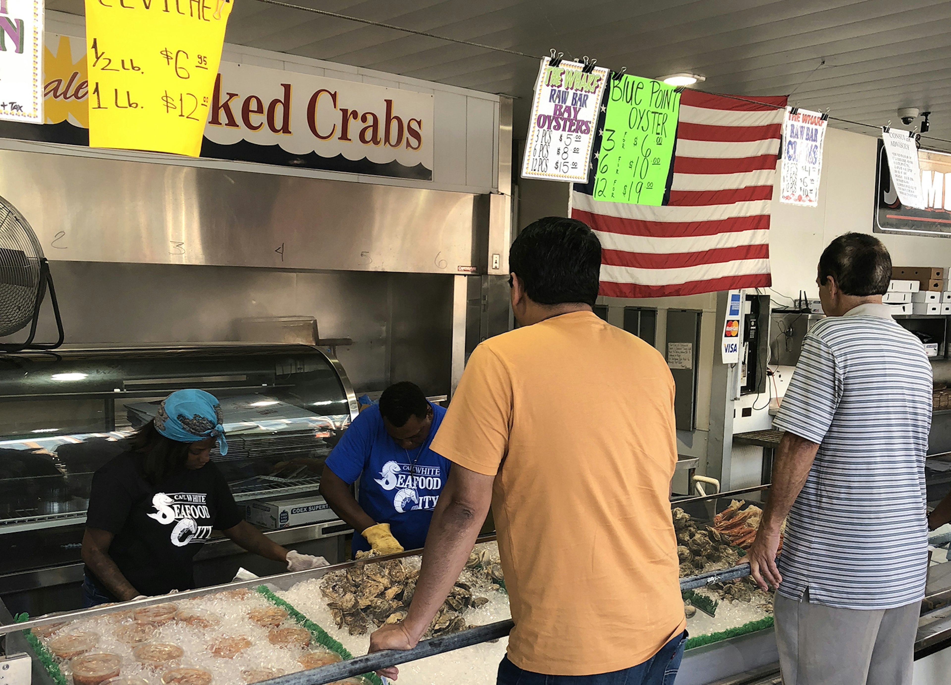 Two men order fresh seafood from a walk-up counter in DC © Trisha Ping / iBestTravel