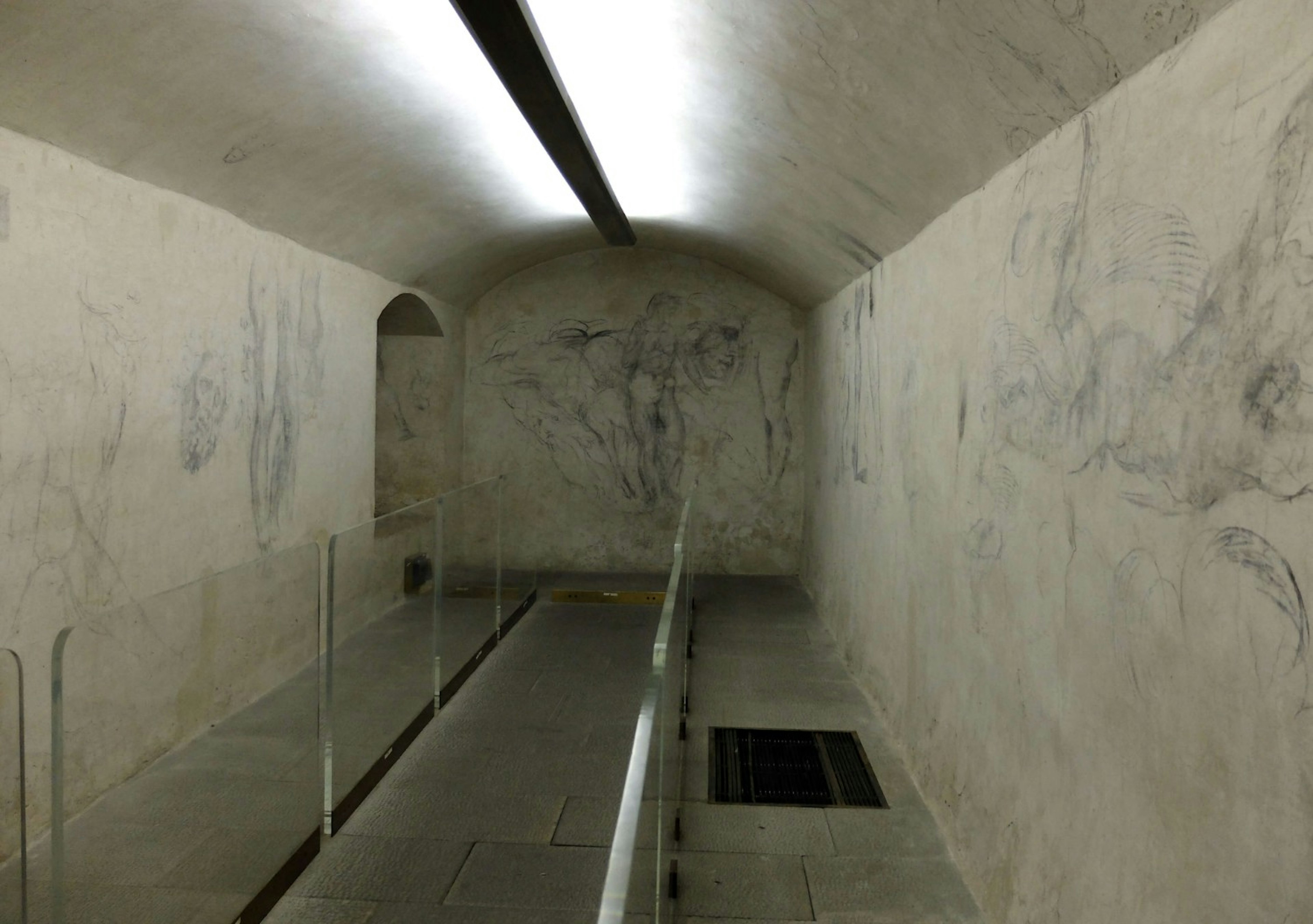 An image of a bare chamber in the Medici Chapels, Florence; its walls have charcoal sketches by Michelangelo on the walls.