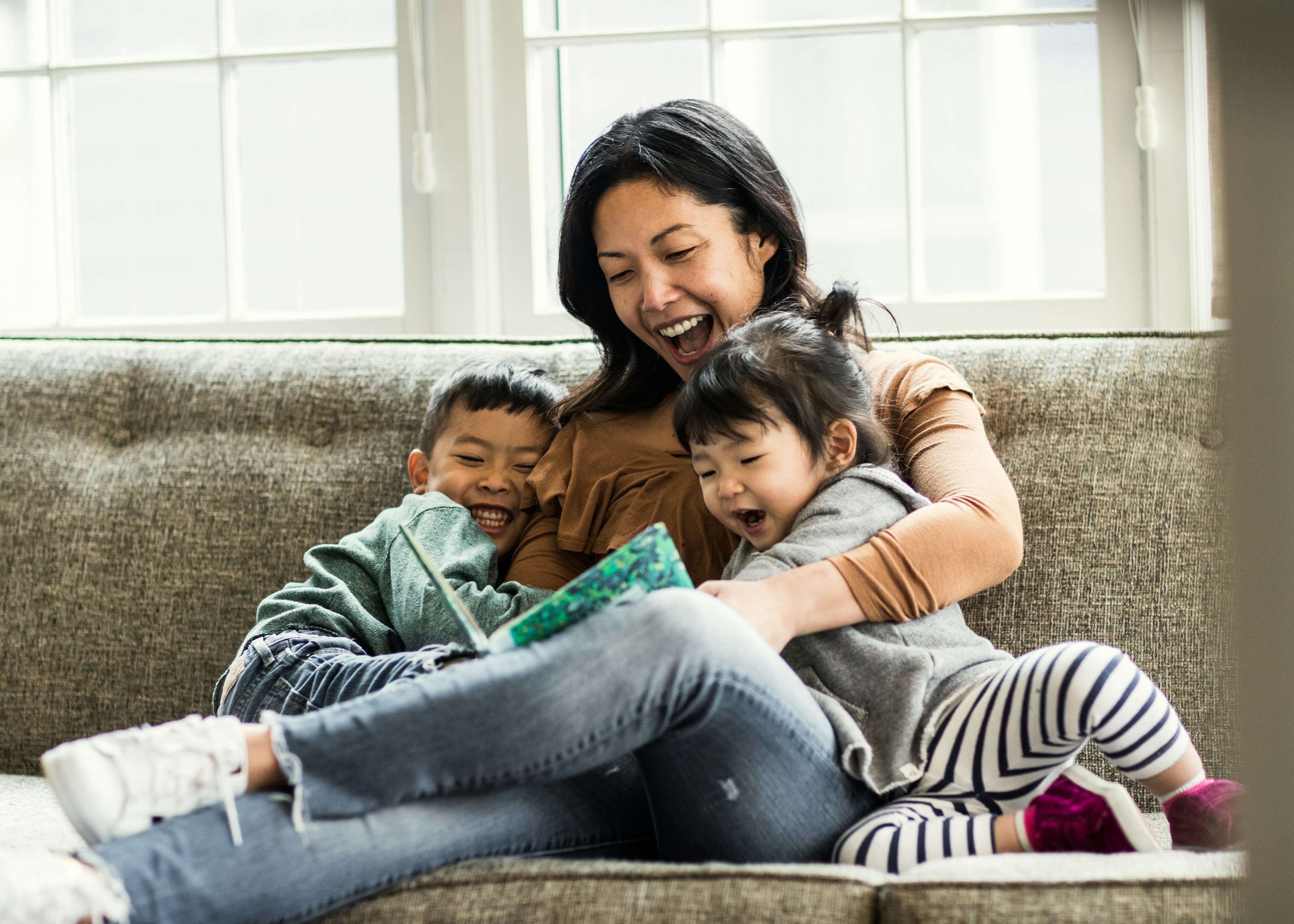 A mother reads to a boy and girl