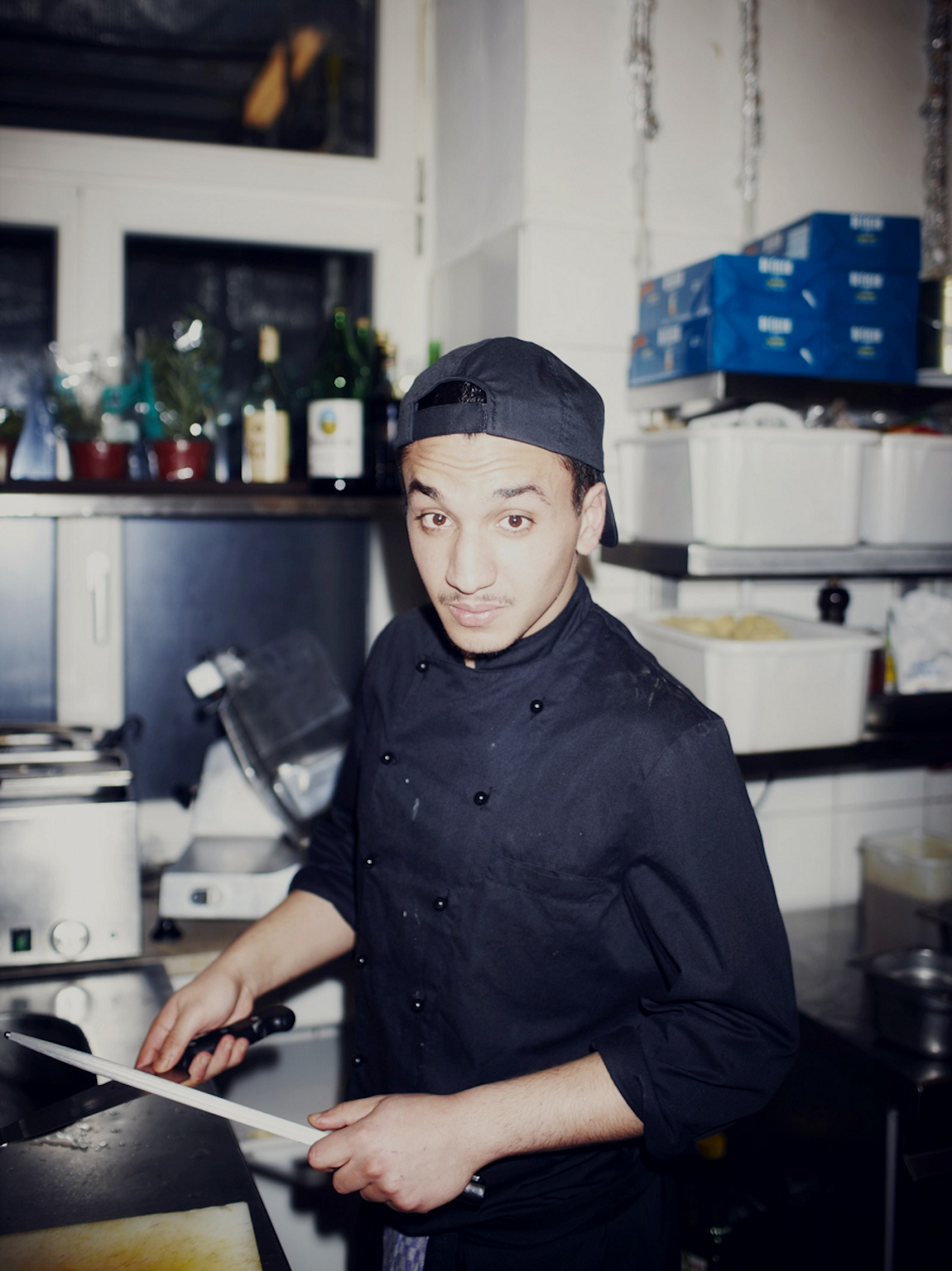 Munich society - a trainnee called Sinan sharpens knives in the Roecklplatz kitchen © Jan Schünke