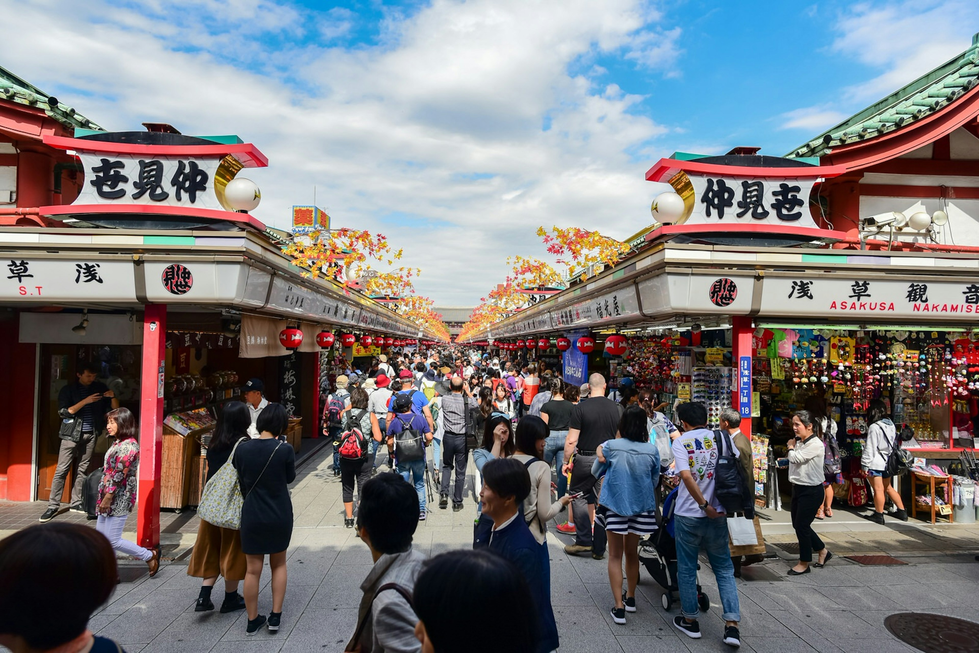 Shoppers walk along Nakamise-dōri shopping street on a clear day in Tokyo