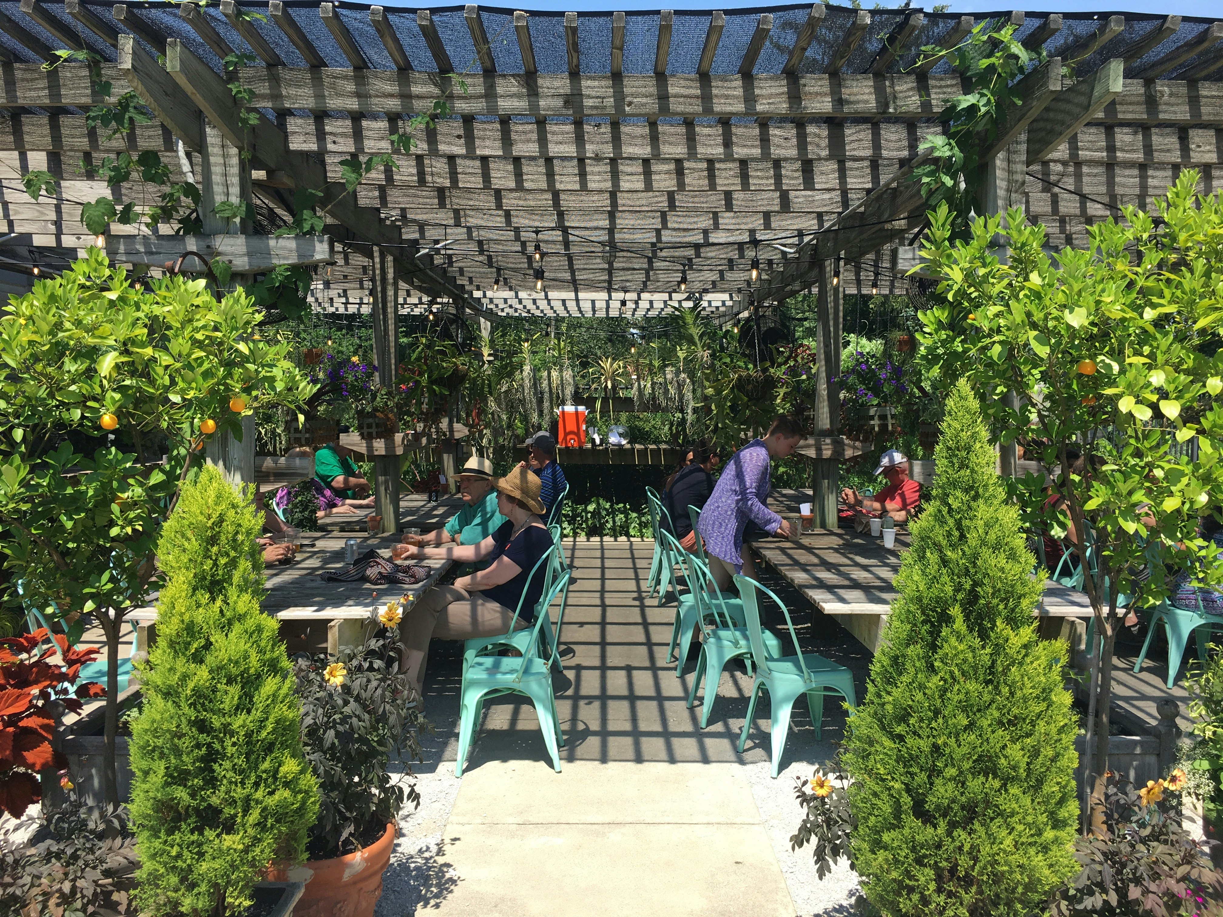 Groups of people sit at assorted tables at an open-air beer garden in Indianapolis