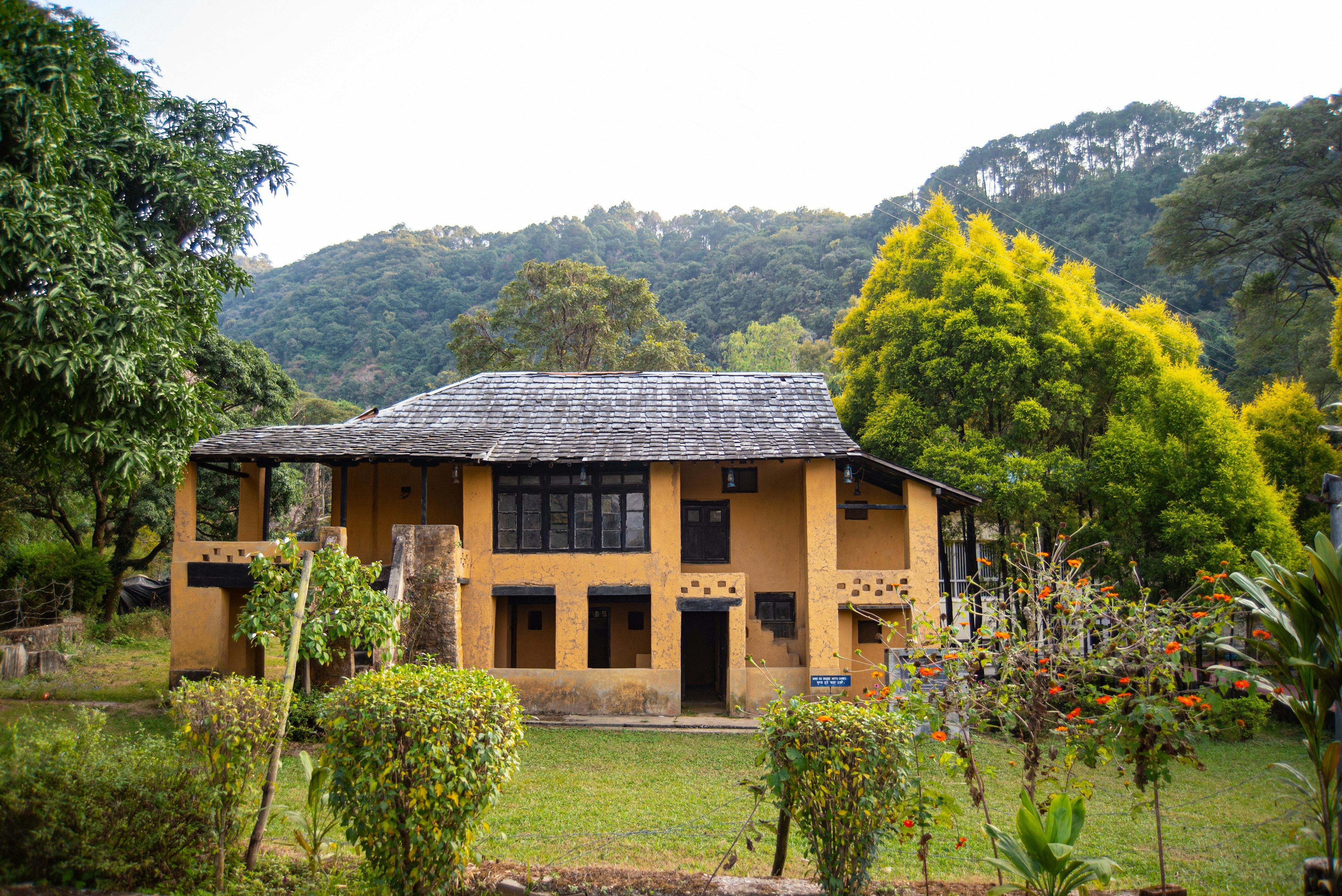 An exterior view of Norah Richards' house in Andretta, which is large, with yellow walls and a slate roof, and is surrounded by greenery on all sides.