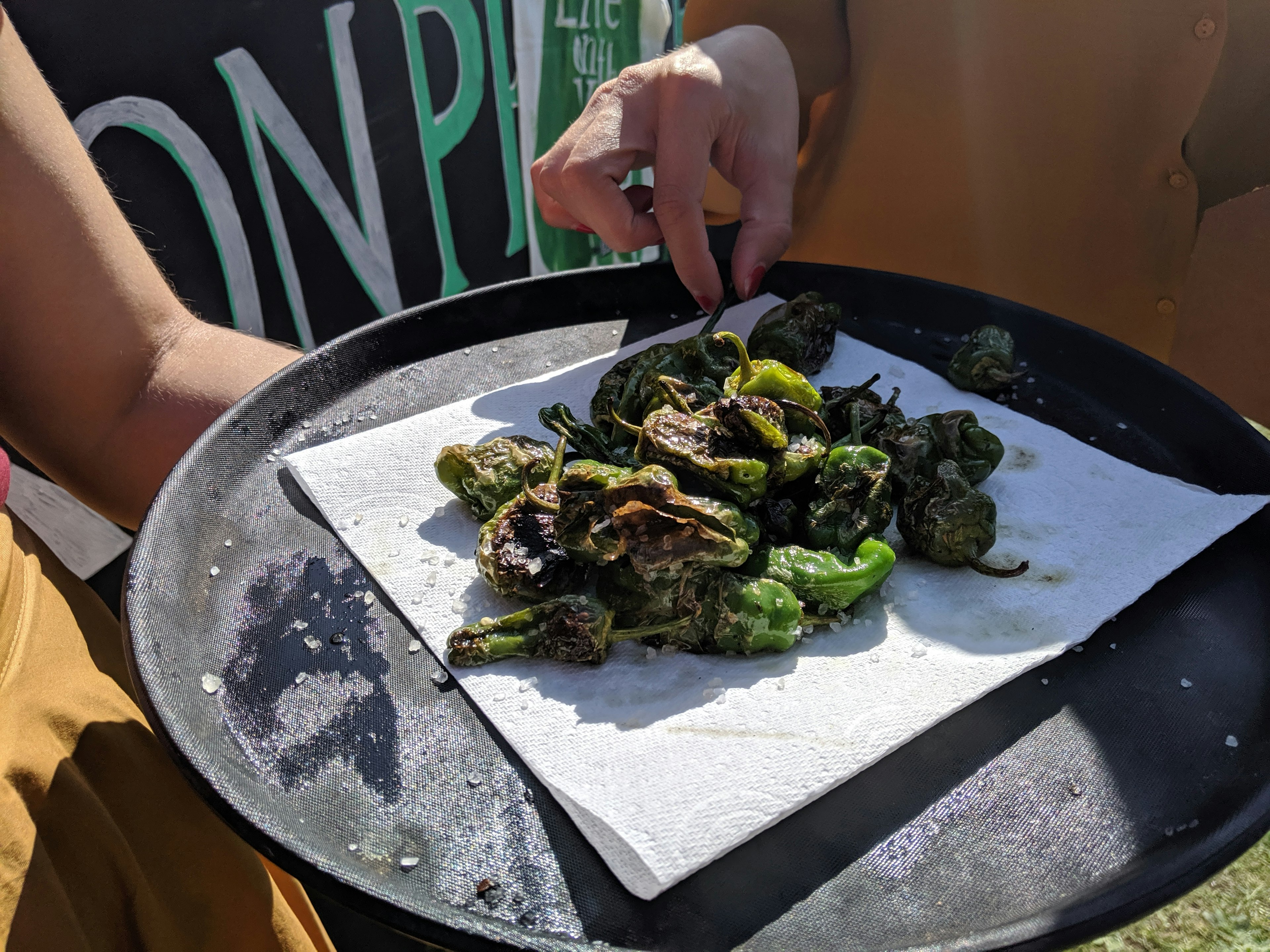 A tray of green padron peppers sprinkled with salt.