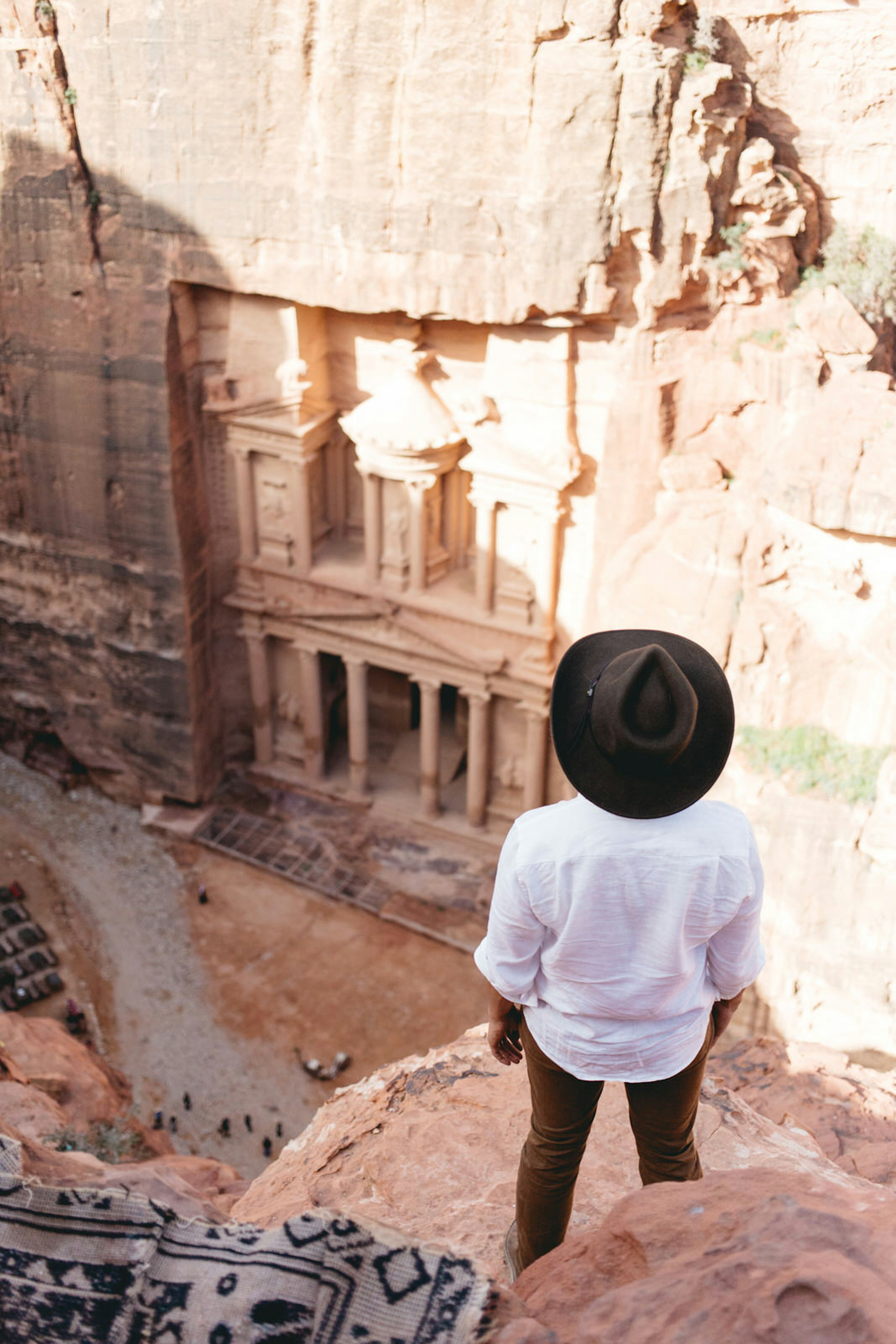 Hiker standing at one of Petra's high places in front of the Treasury, Jordan.