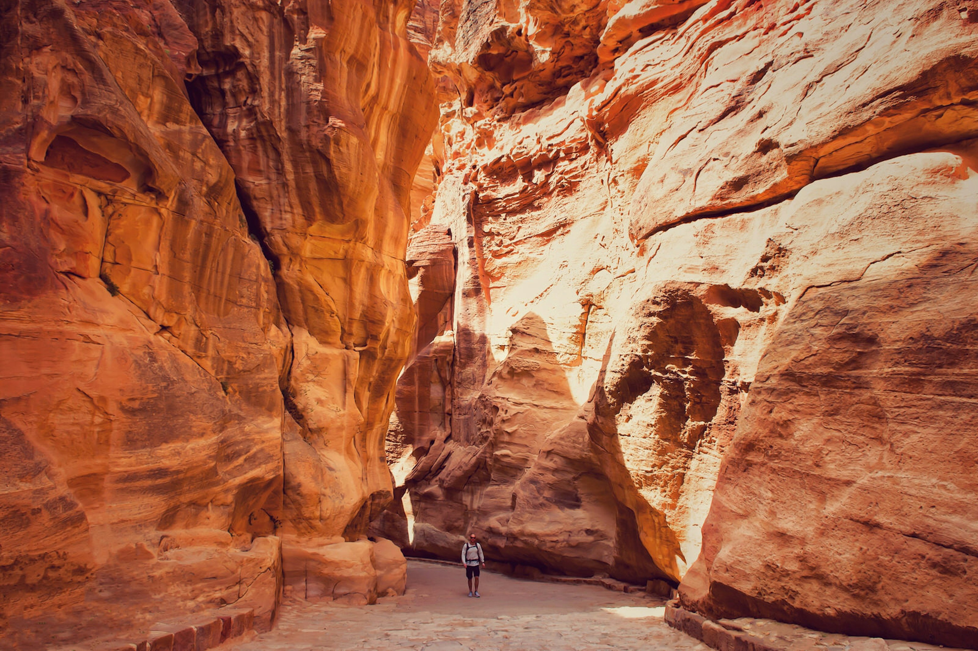 Man hiking through rock formations at Petra, Jordan.