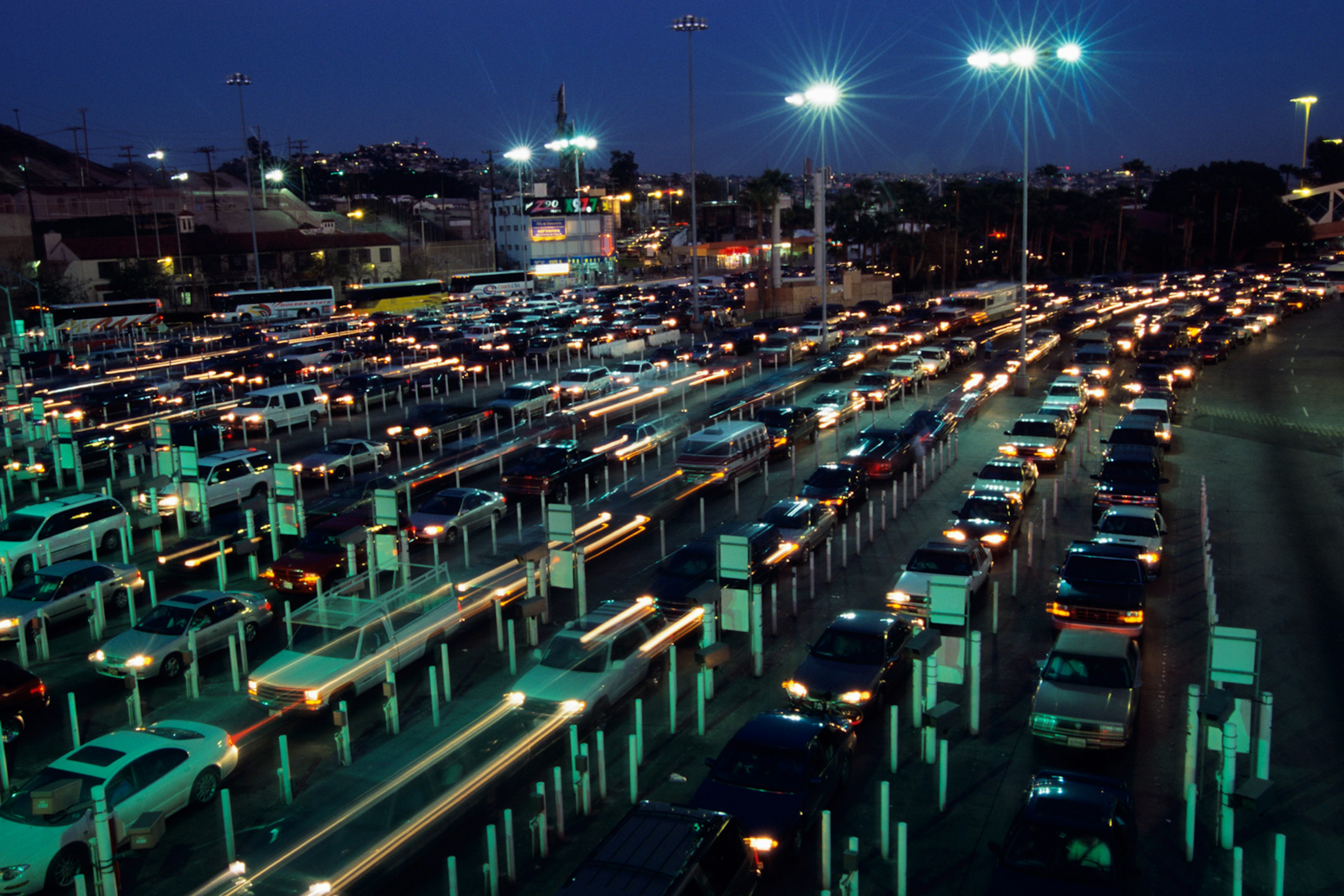 cars line up under glaring lights