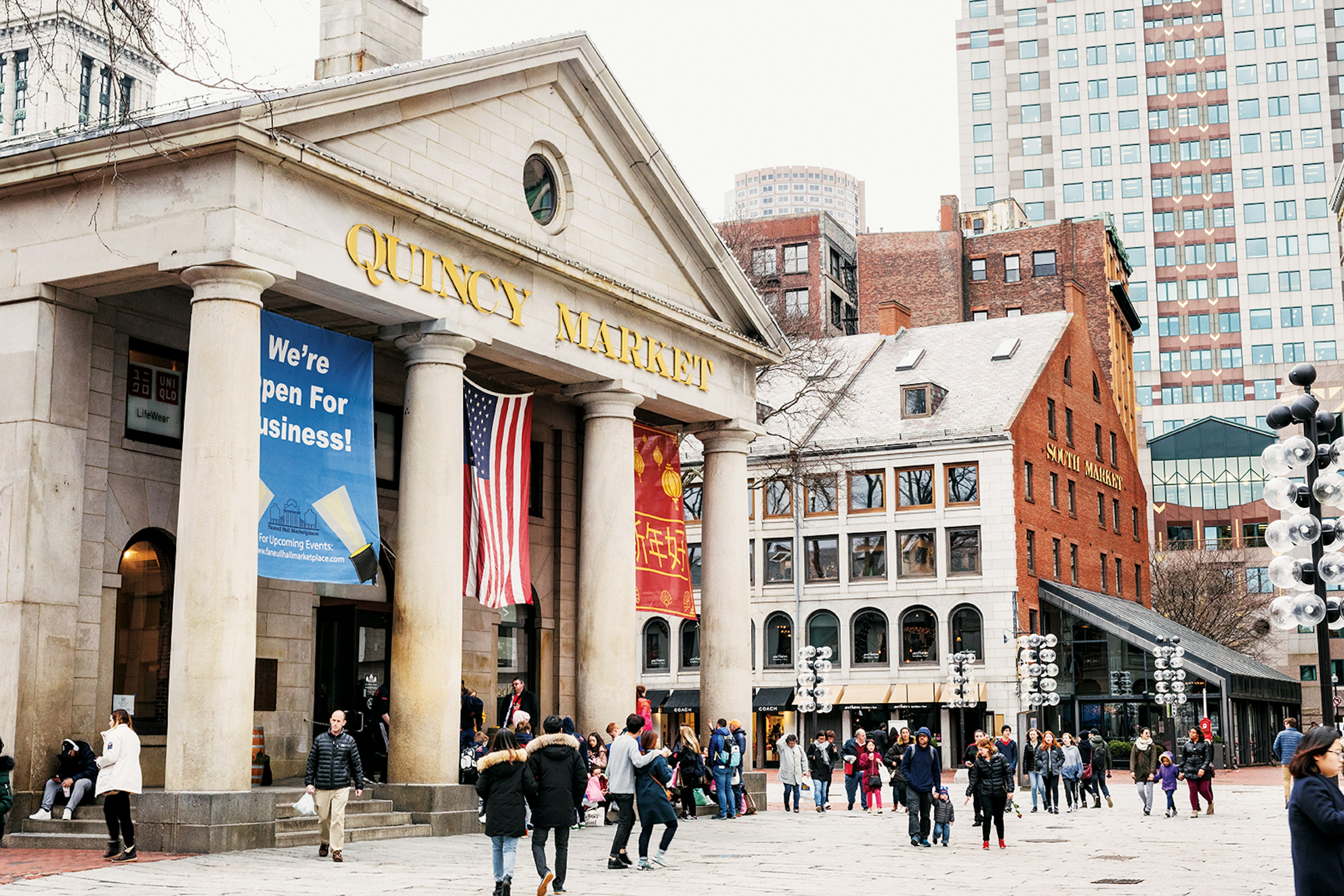 wide exterior shot of Quincy Market, a Greek Revival building in Boston with four columns © Adam DeTour / Lonely Planet