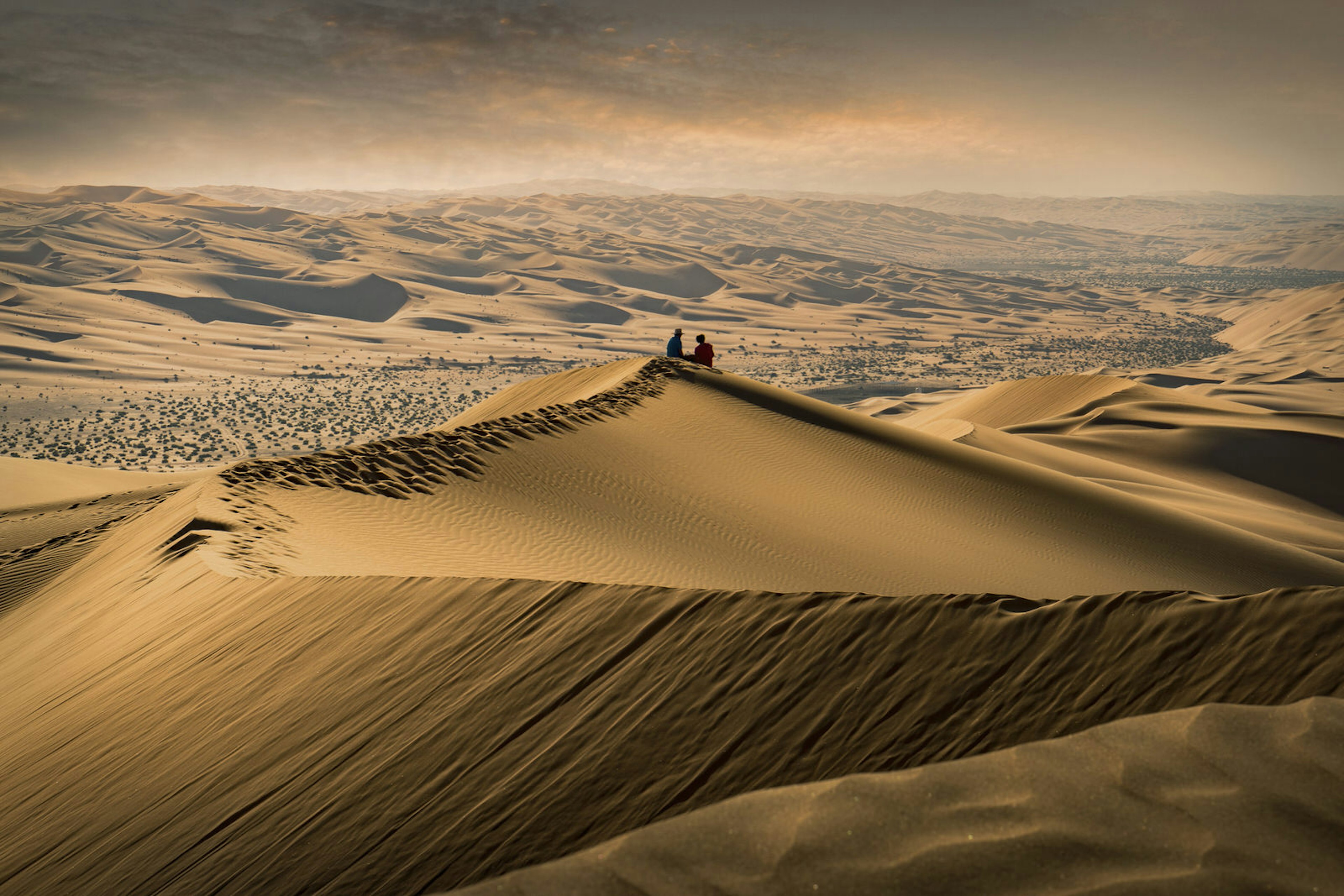 608759463
contemplation, serenity, love, tranquility, travel
A couple sitting on the top of a giant sand dune in the desert watching the sunset in the Empty Quarter, or Rub al Khali,  the world's largest sand desert