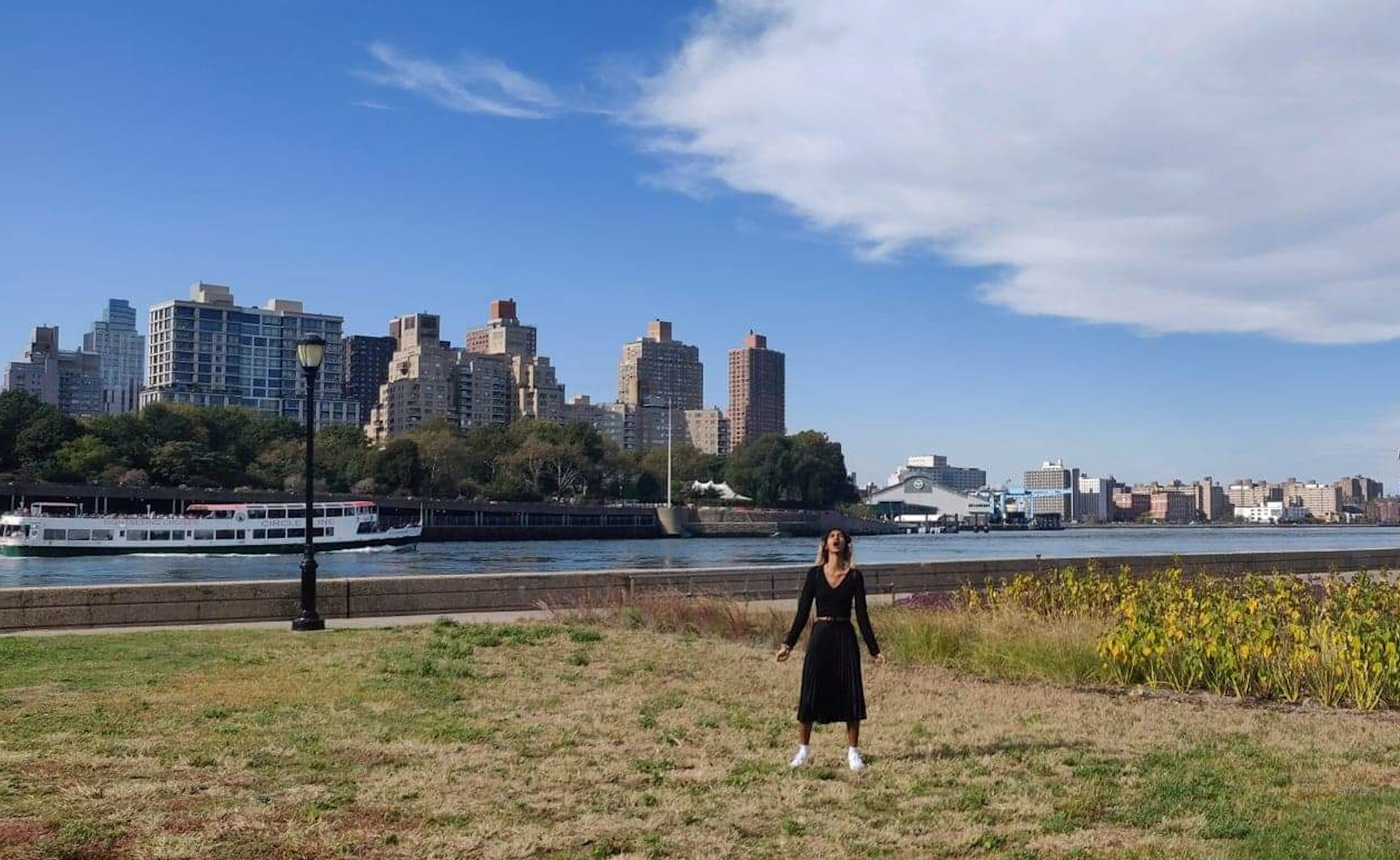 Young woman in coat screams by a Manhattan harbour