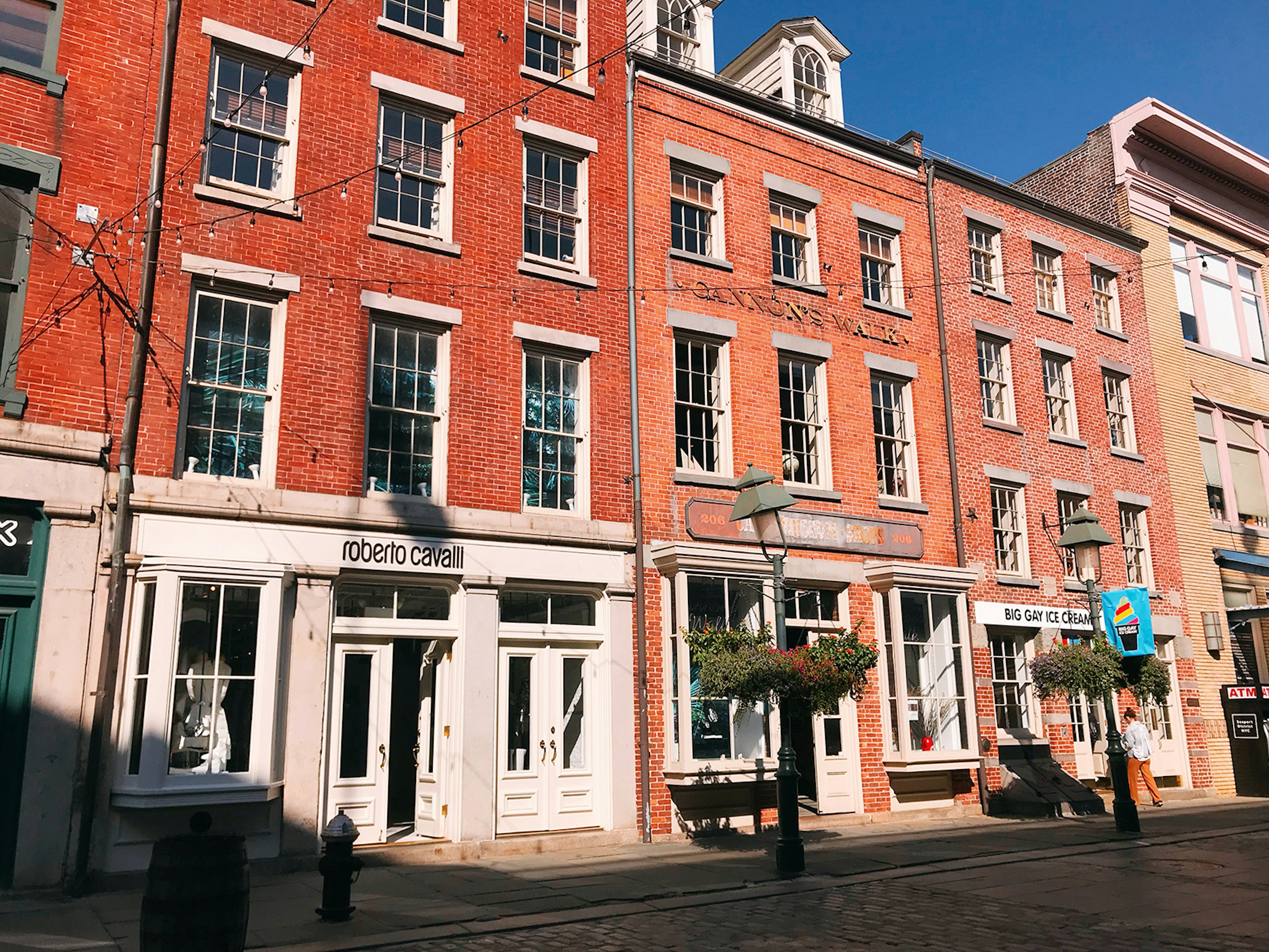 A row of shops in four-story buildings from the 18th century line a street in NYC