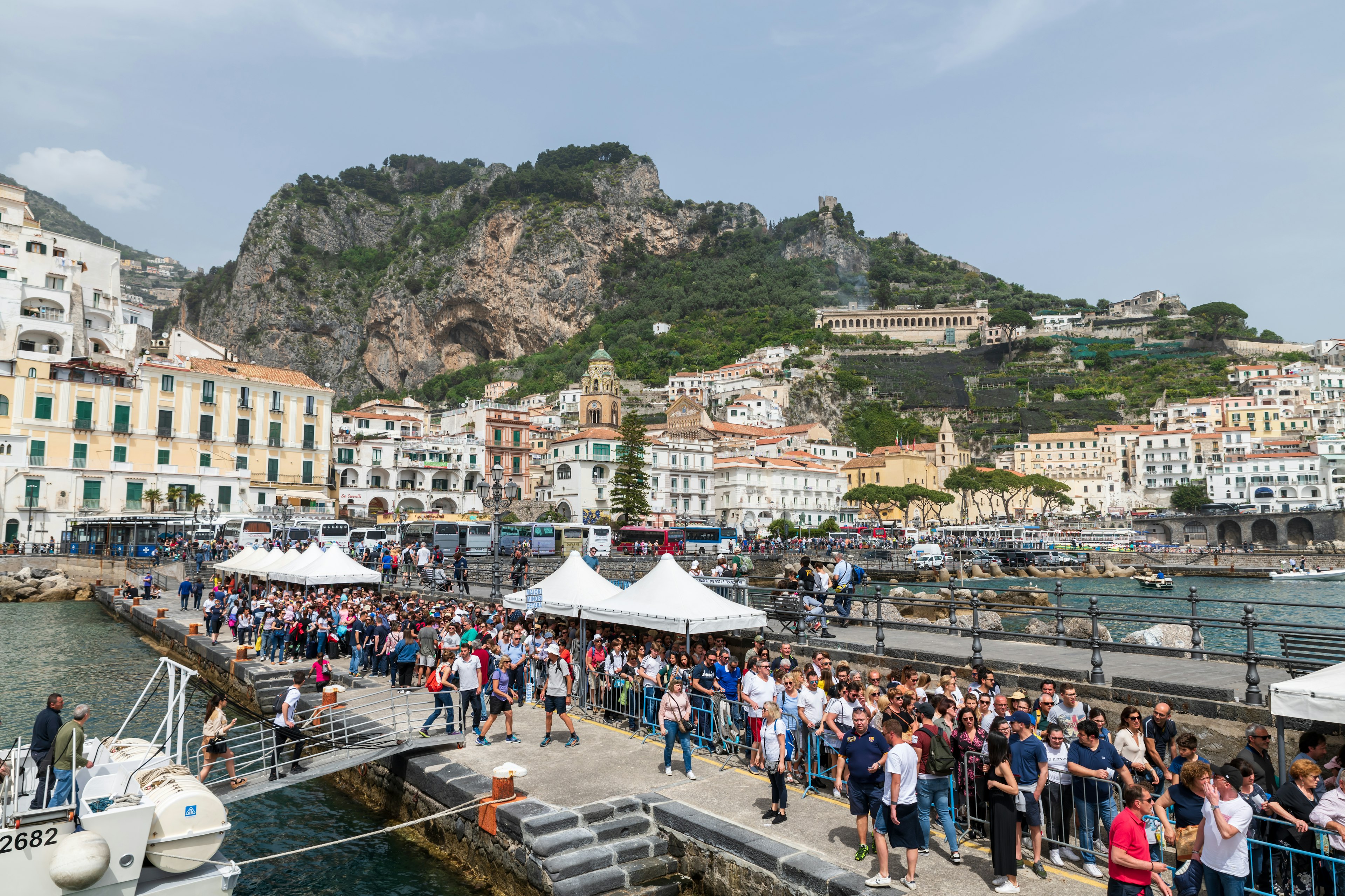 Amalfi (Salerno) -- a view of the little port with many tourists lined up to embark.,