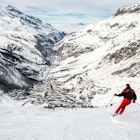 Skiers on the piste with the village of Val d'isere on the background. The skier is motion blurred. Val d'isere, france, License Type: media, Download Time: 2024-08-28T18:49:09.000Z, User: brianaellisgibbs44, Editorial: false, purchase_order: 56500, job: Global Publishing WIP, client: Epic Snow Adventures, other: Briana Ellis-Gibbs