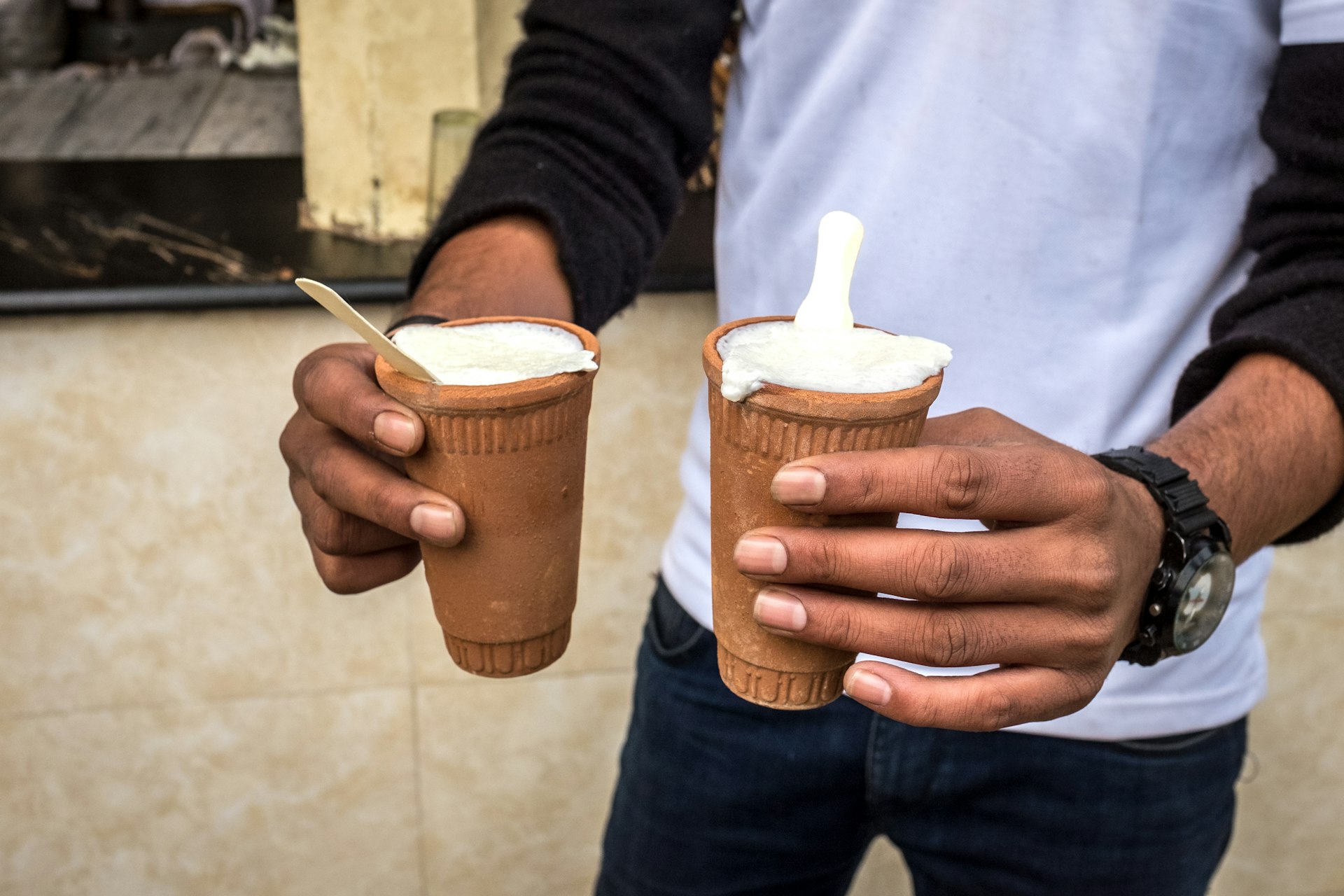 Man holding two cups of lassi in Jaipur, in Rajasthan, India.