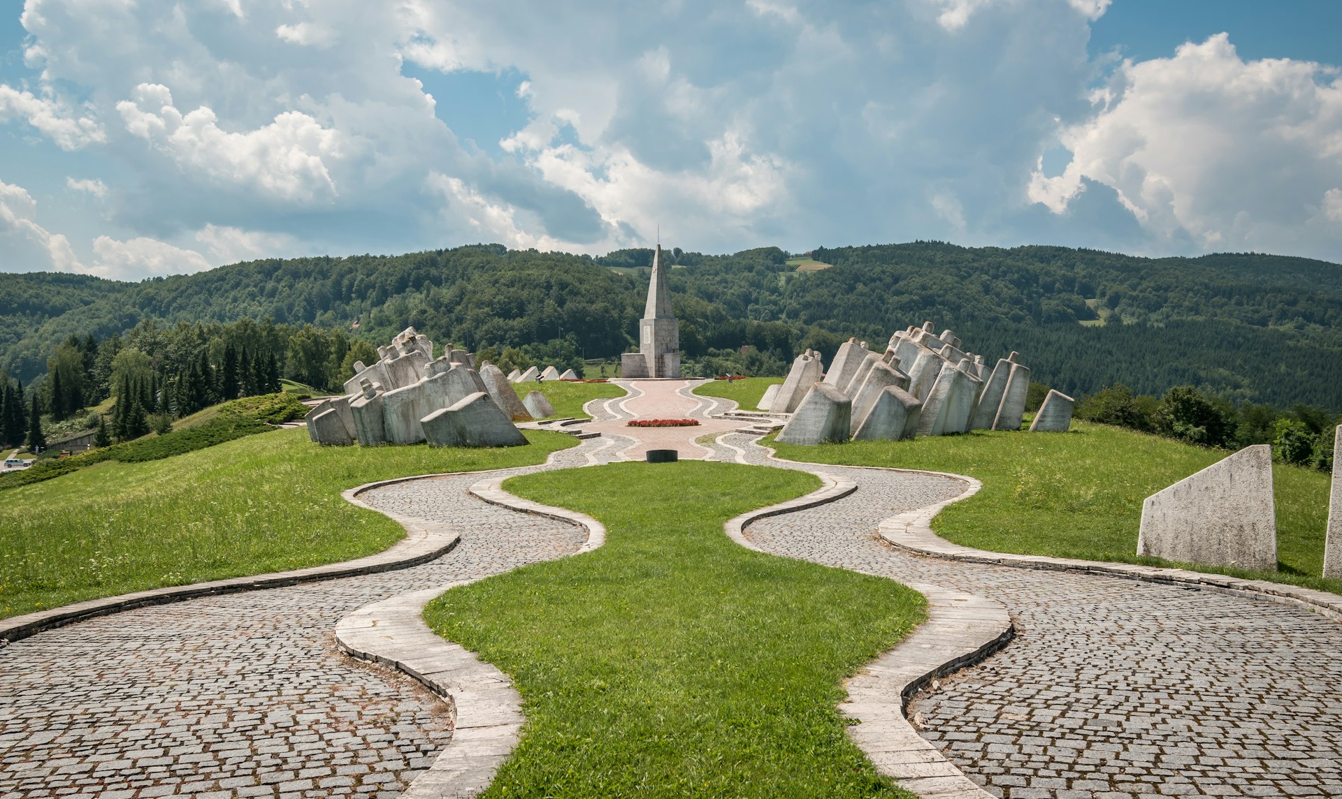 A neat memorial ground with large white stones and a church at the end of a path