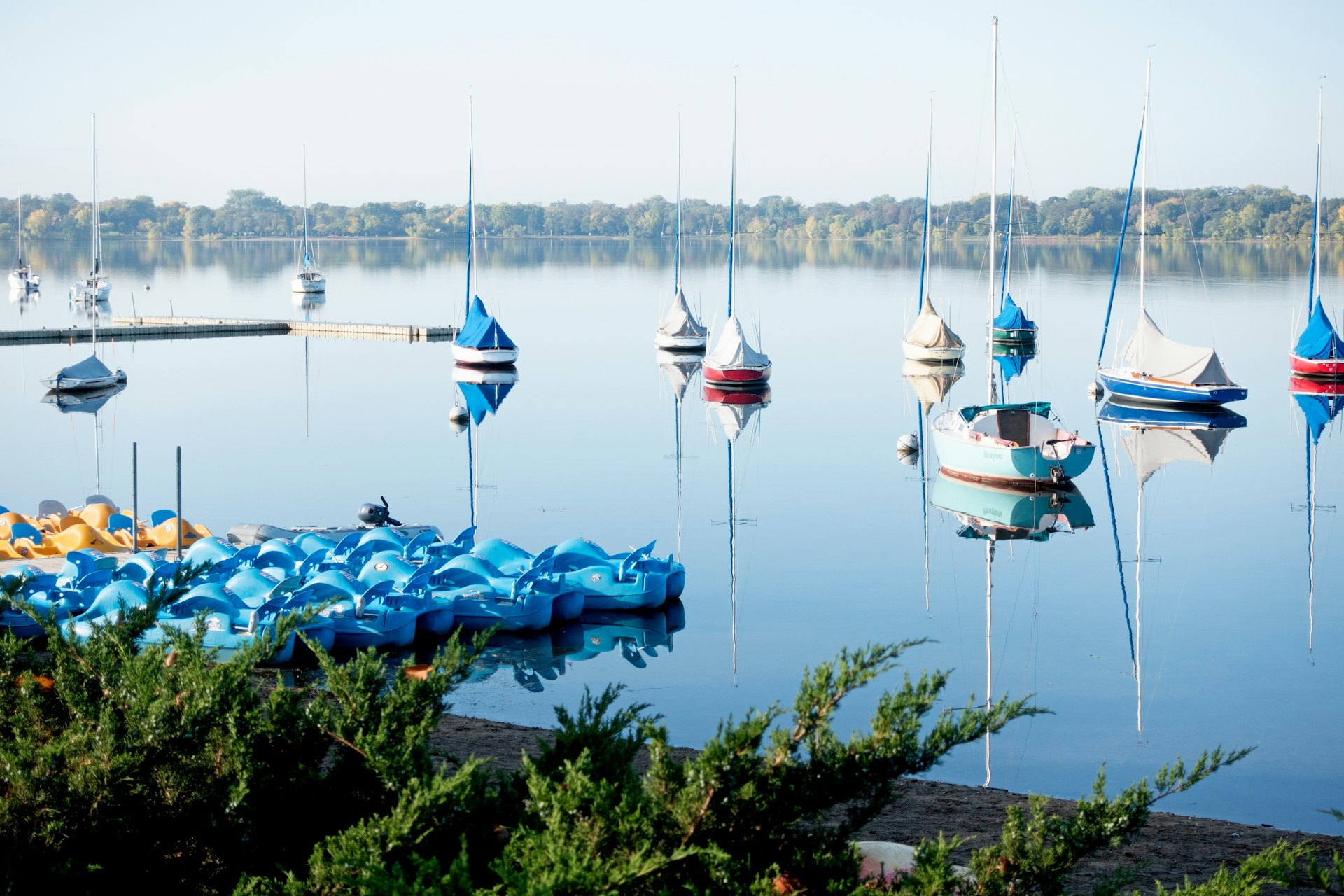 Small sail boats anchored on a peaceful lake