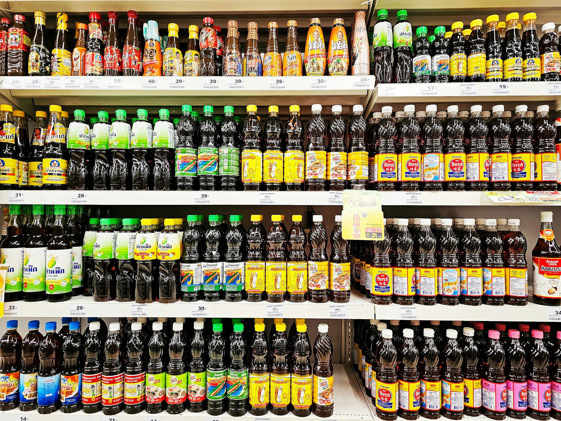 Various brands of Thai fish sauce on market shelves. Window display of fish sauce in supermarket. 