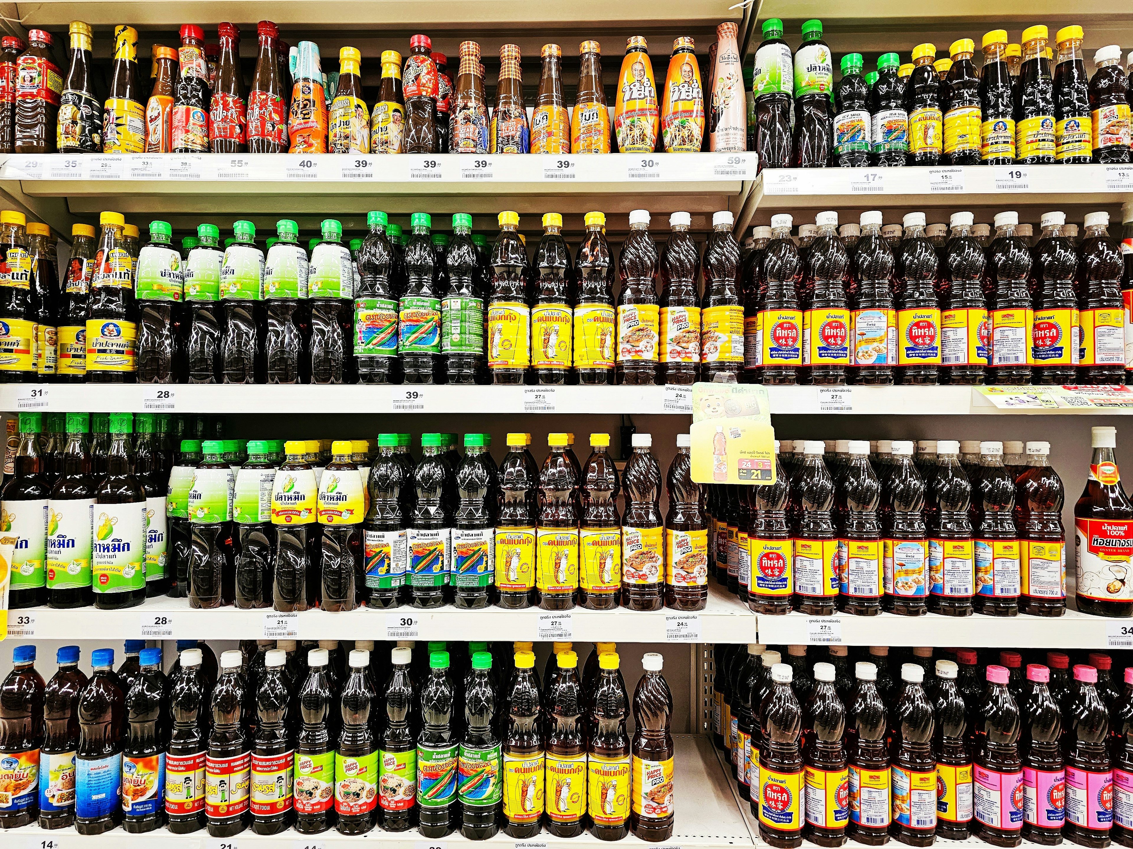 Various brands of Thai fish sauce on market shelves. Window display of fish sauce in supermarket.