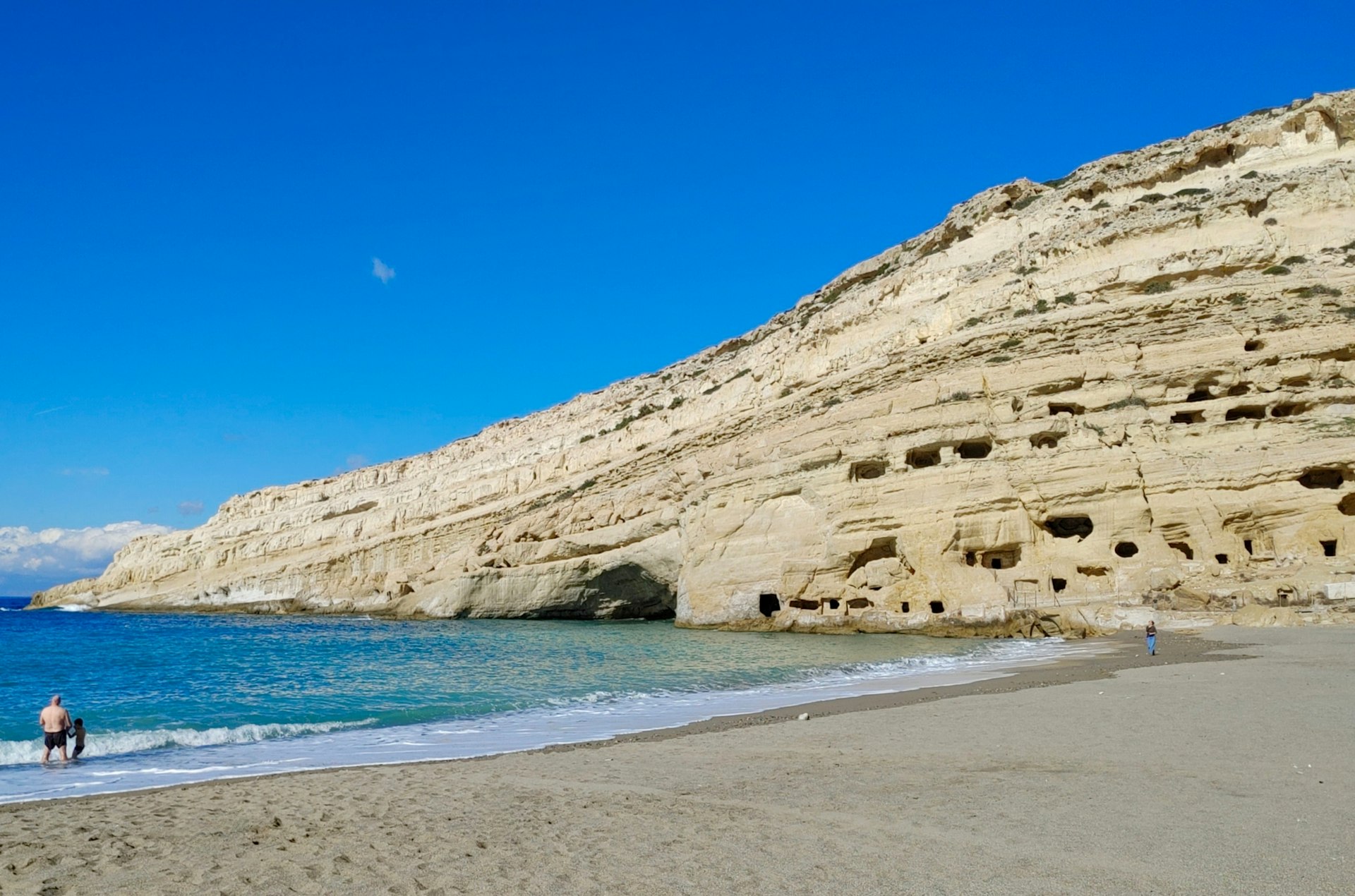 A man walks on the empty beach of Matala, Crete, in winter