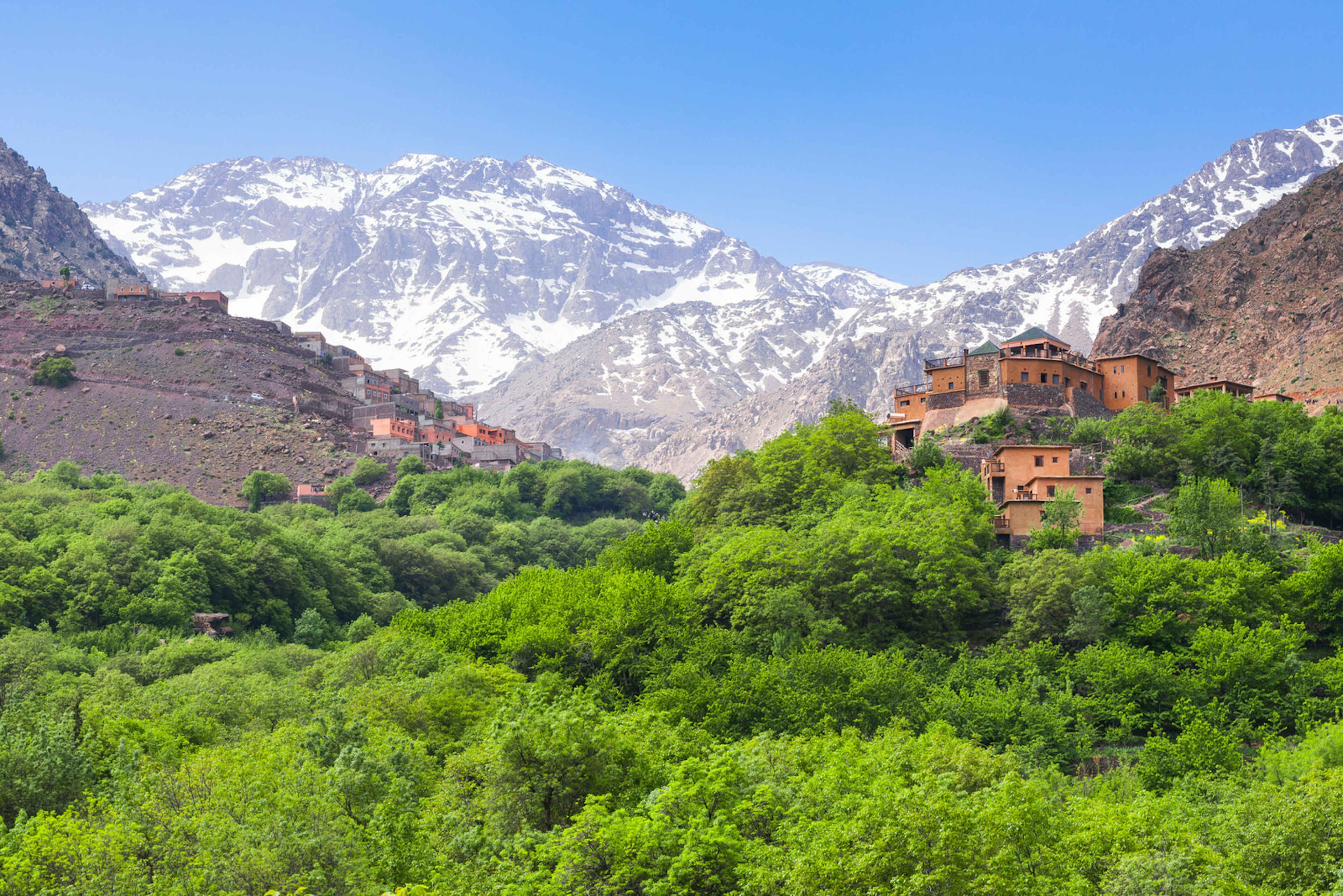 Teracotta houses in the village of Imlil in the Moroccan Atlas Mountains, backed by snow-covered peaks © Alberto Loyo / Shutterstock