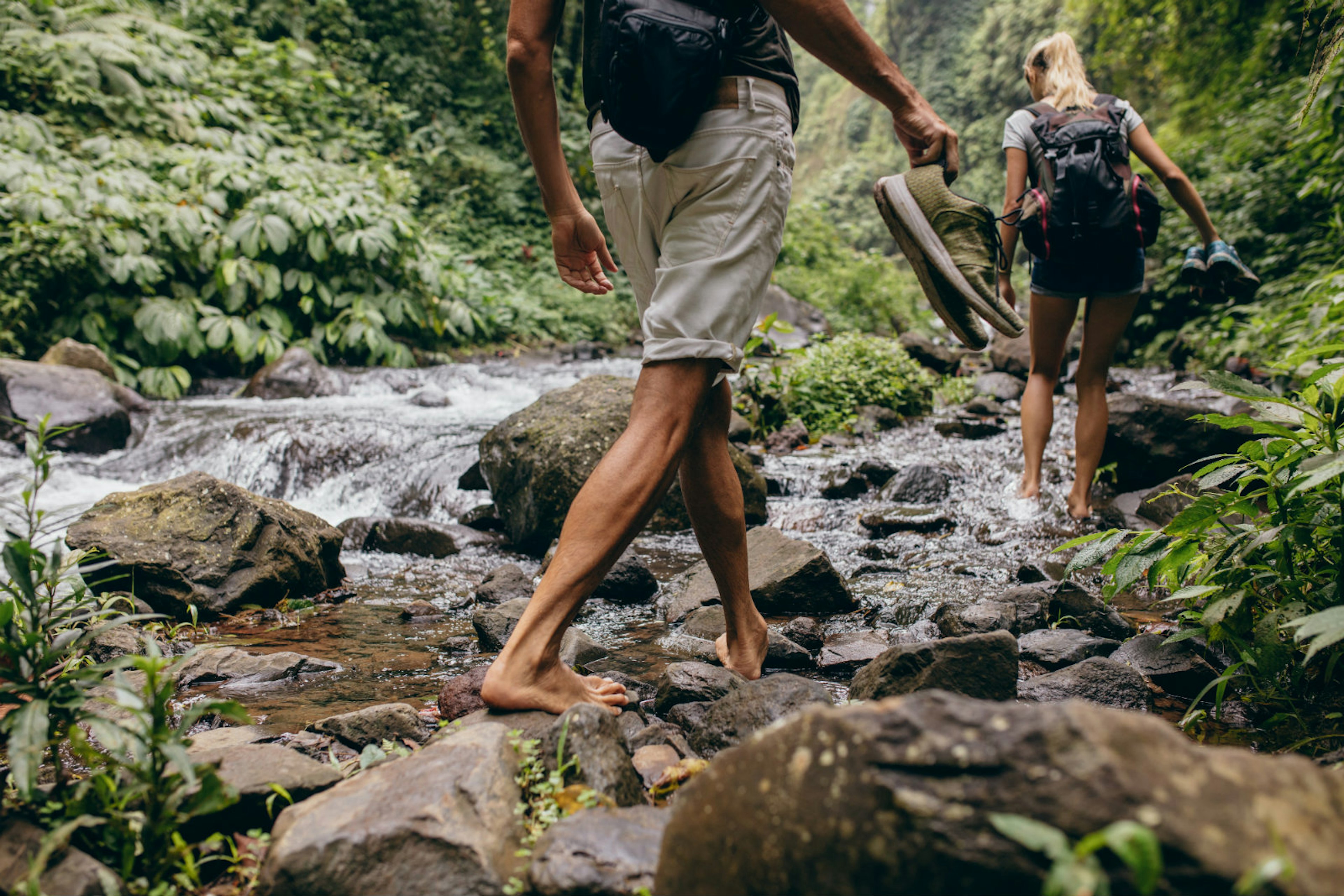 Minimoon magic: a couple hike upstream in a forest © Jacob Lund / Shutterstock