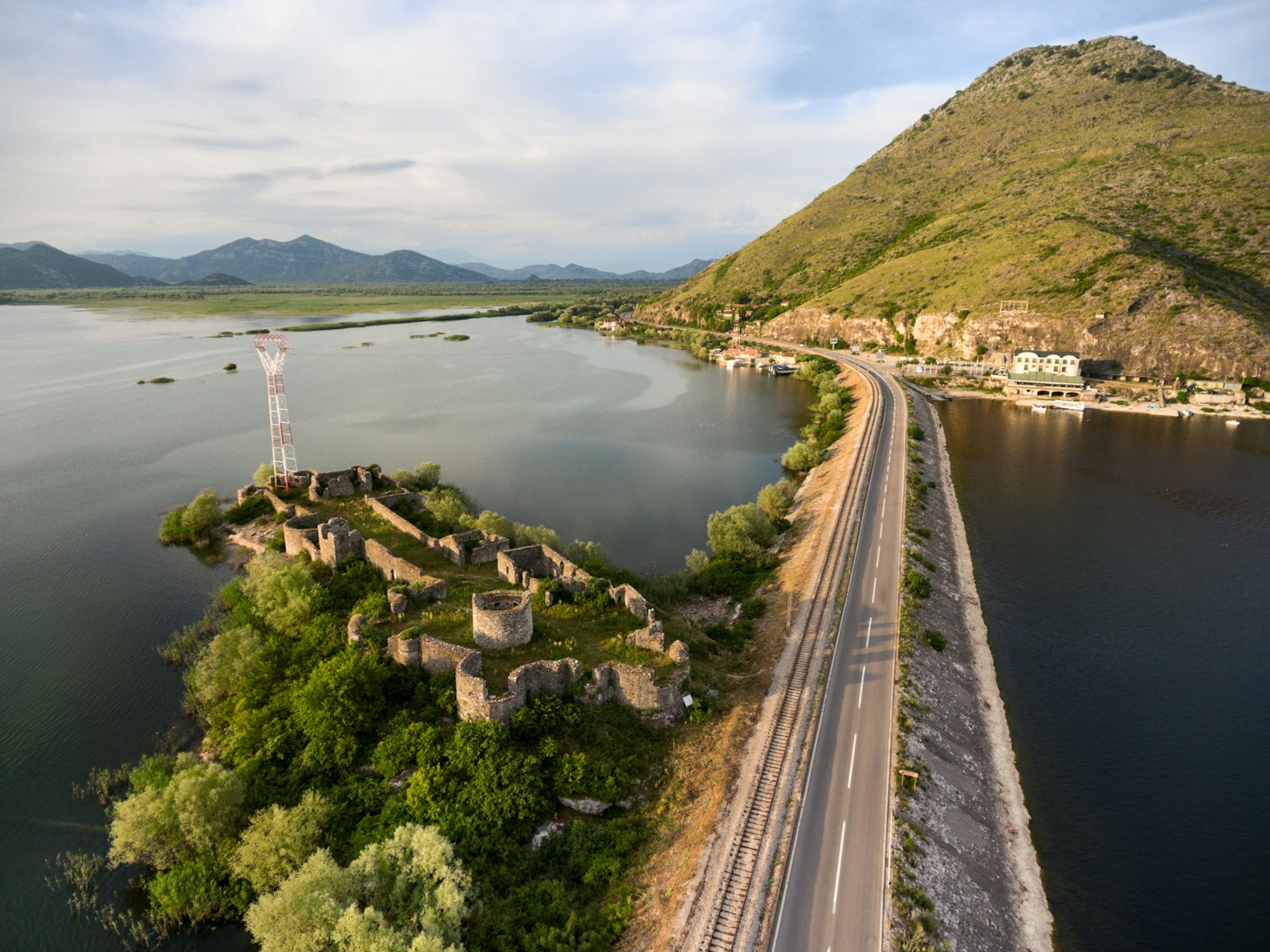 The train skirts the Lesendro Fortress ruins on Lake Skadar on its way to the Adriatic