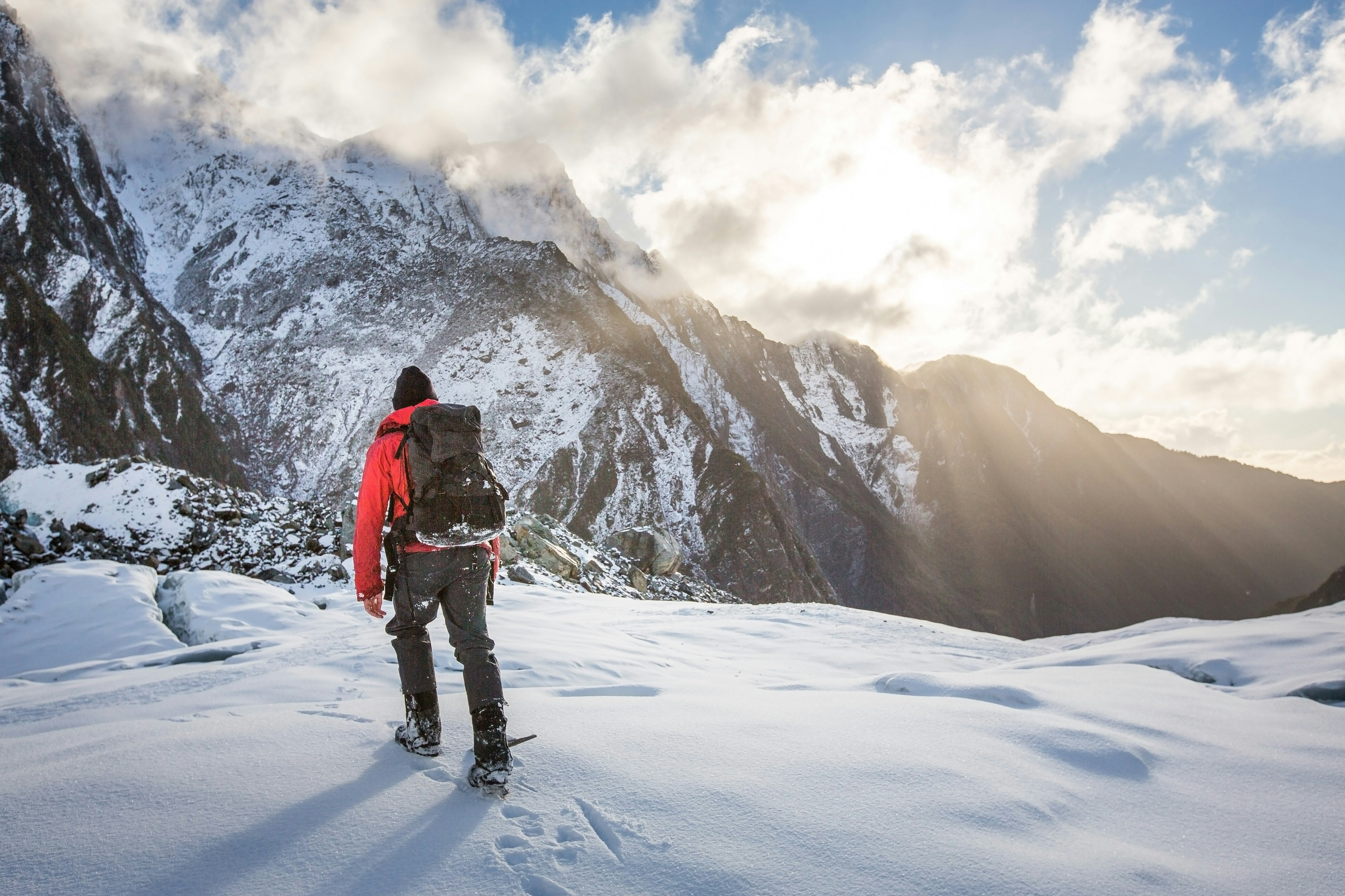 Hiker on snow-covered mountain trail