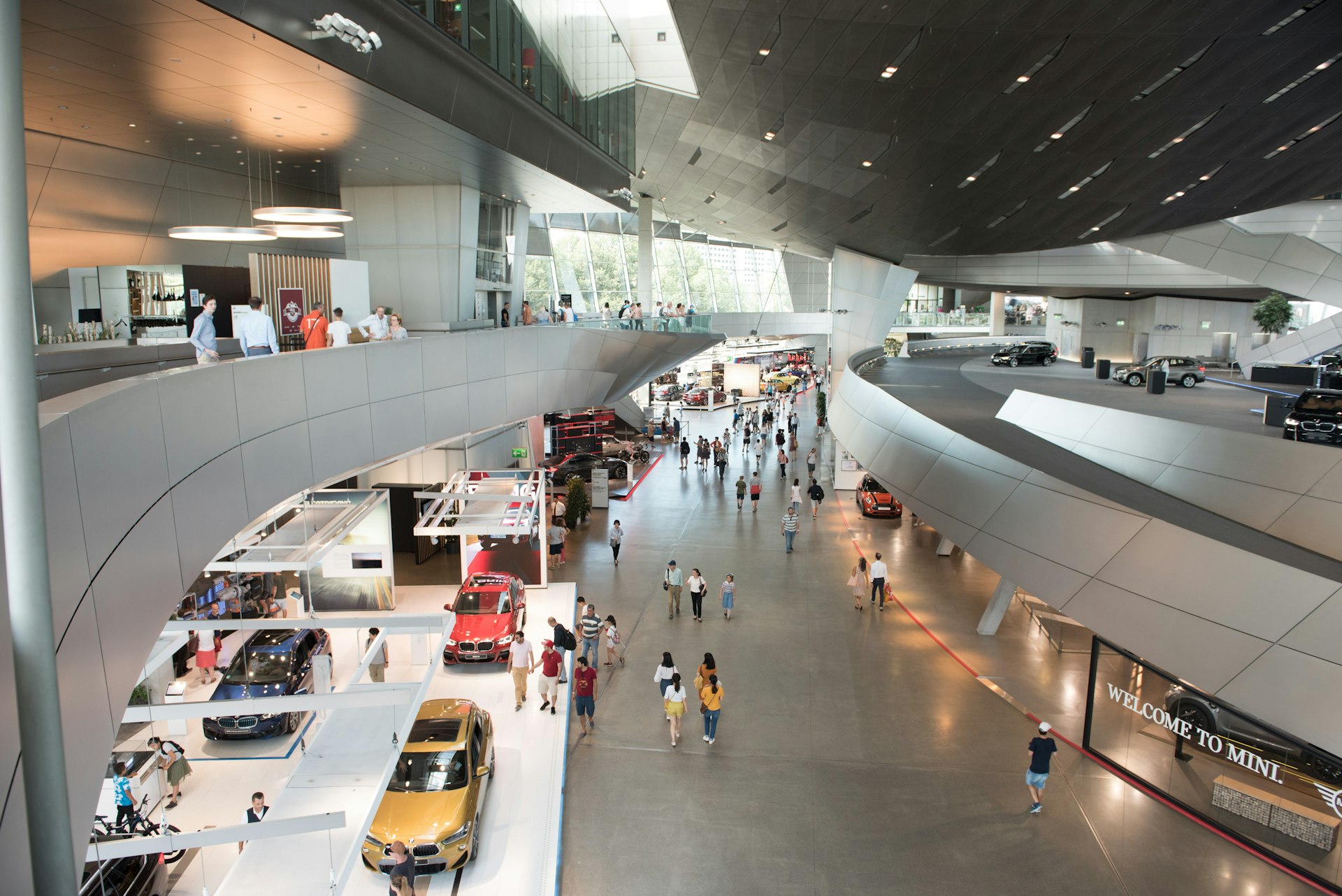 Visitors admire cars in the huge, ultra-modern galleries of BMW Welt, Munich