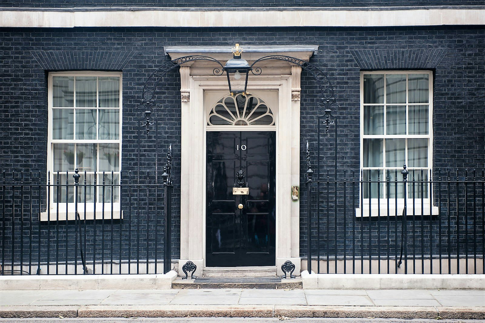 A black door with a number 10 on it set in a brick wall