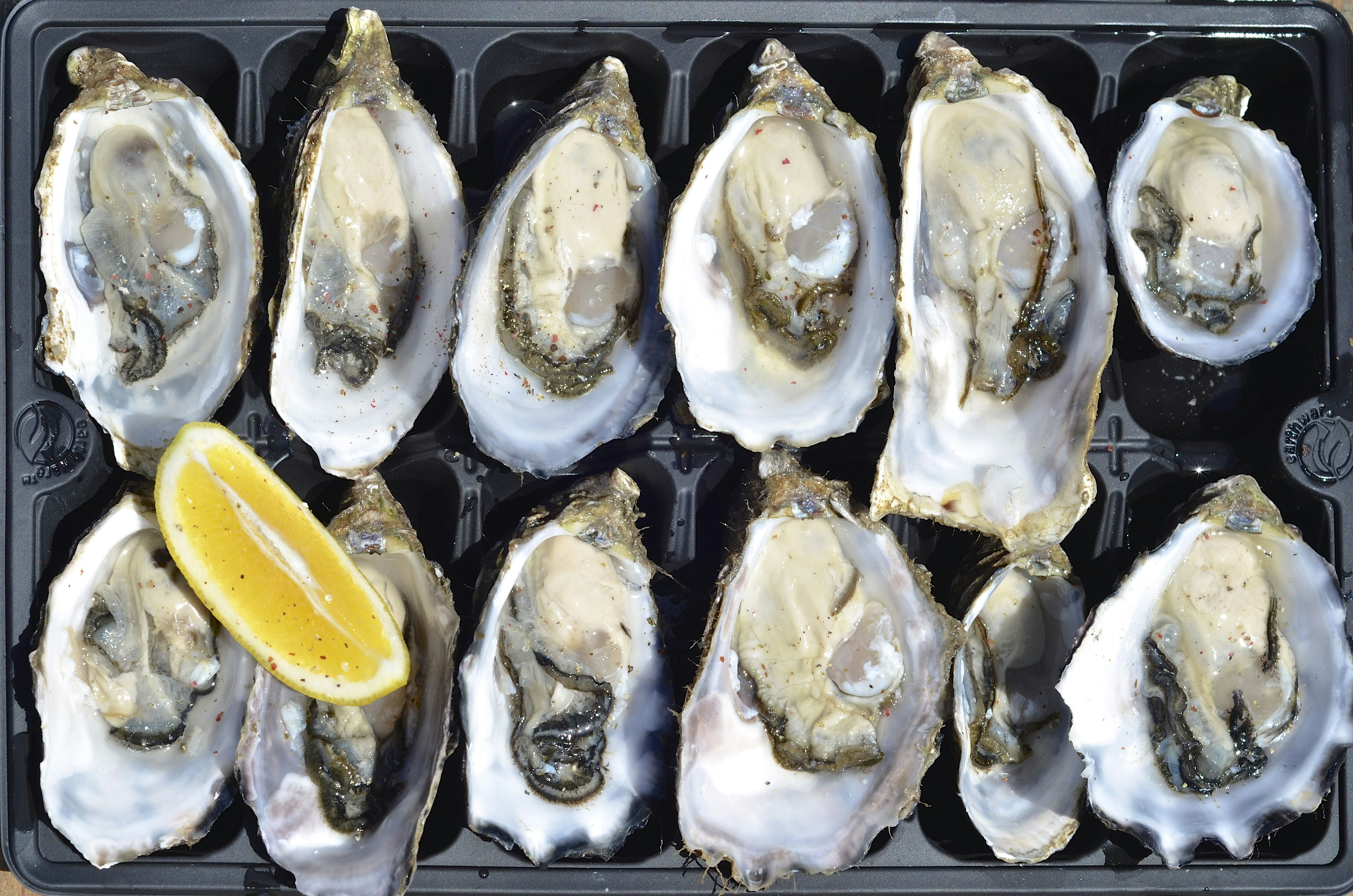 Kangaroo Island food - fresh oysters with a wedge of lemon and sprinkling of chilli on Kangaroo Island, Australia