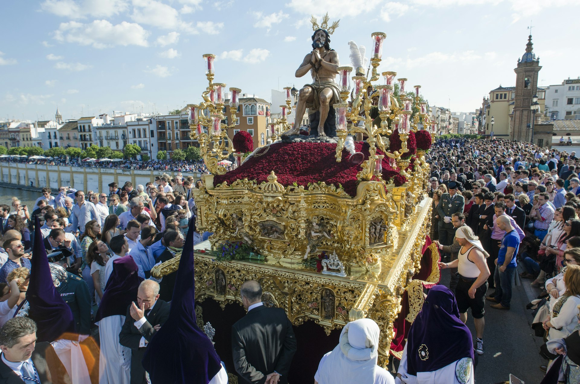 The brotherhood of "La Estrella" in a procession across the bridge of Triana during Semana Santa in Seville. 