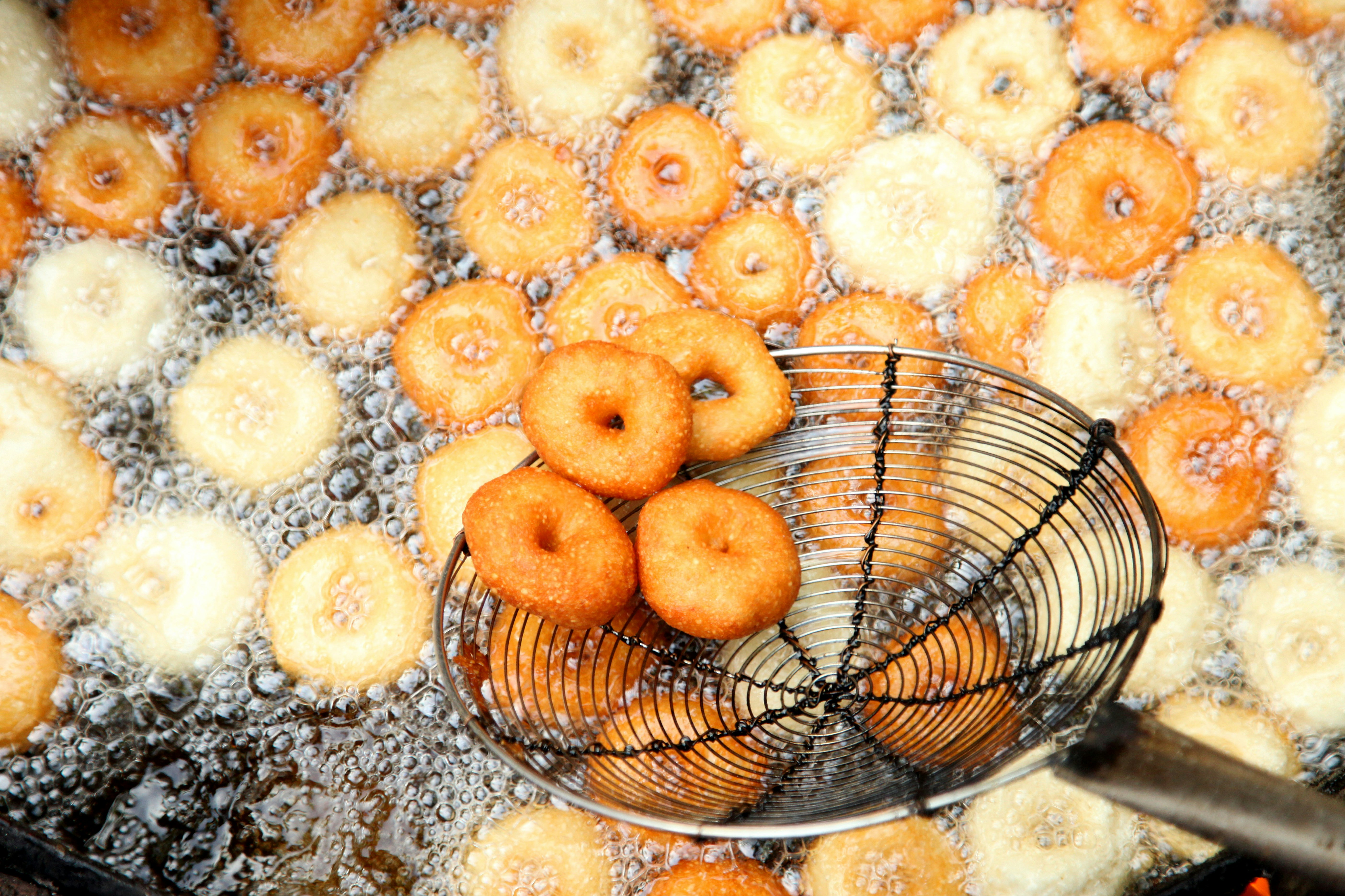 Vada (lentil-flour fritters) frying in oil in South India.