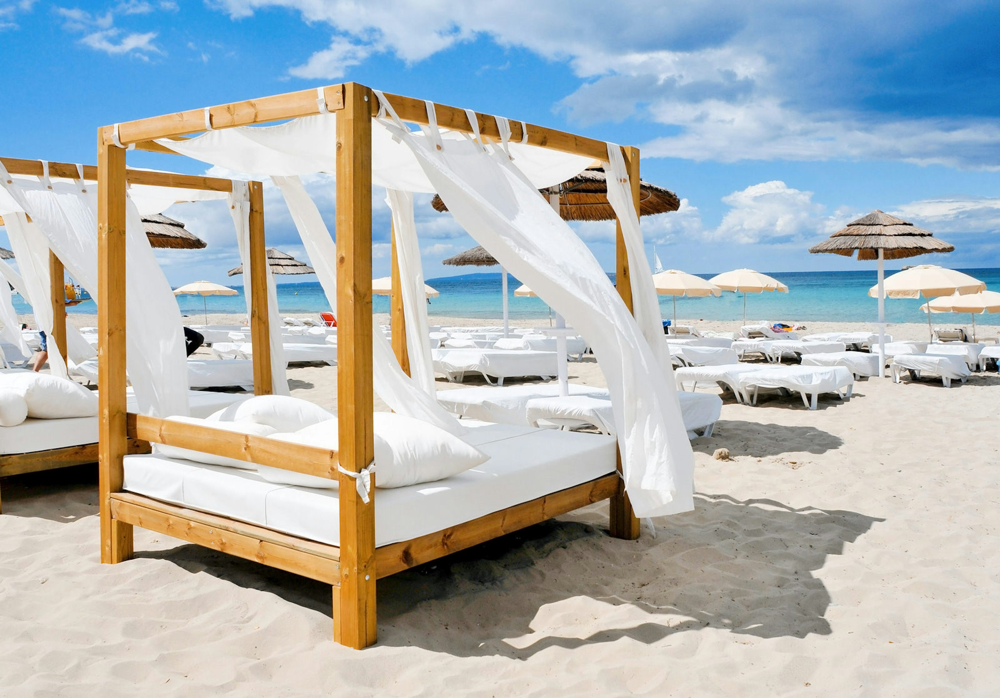 Ibiza spa breaks - white beds and lounges on a white sand beach at Ibiza.