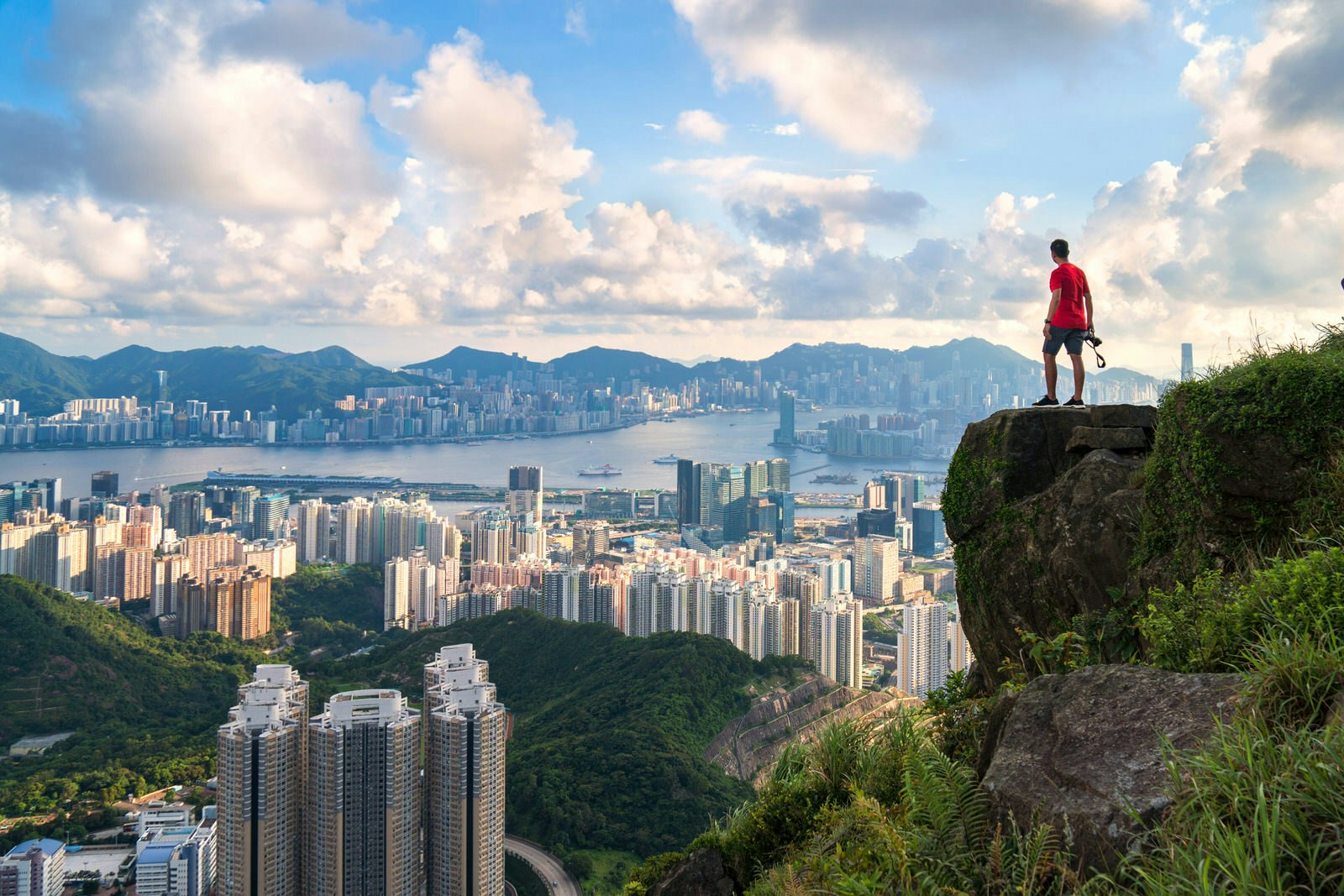 Man stands on edge of cliff overlooking Hong Kong © Ekaphon maneechot / Shutterstock