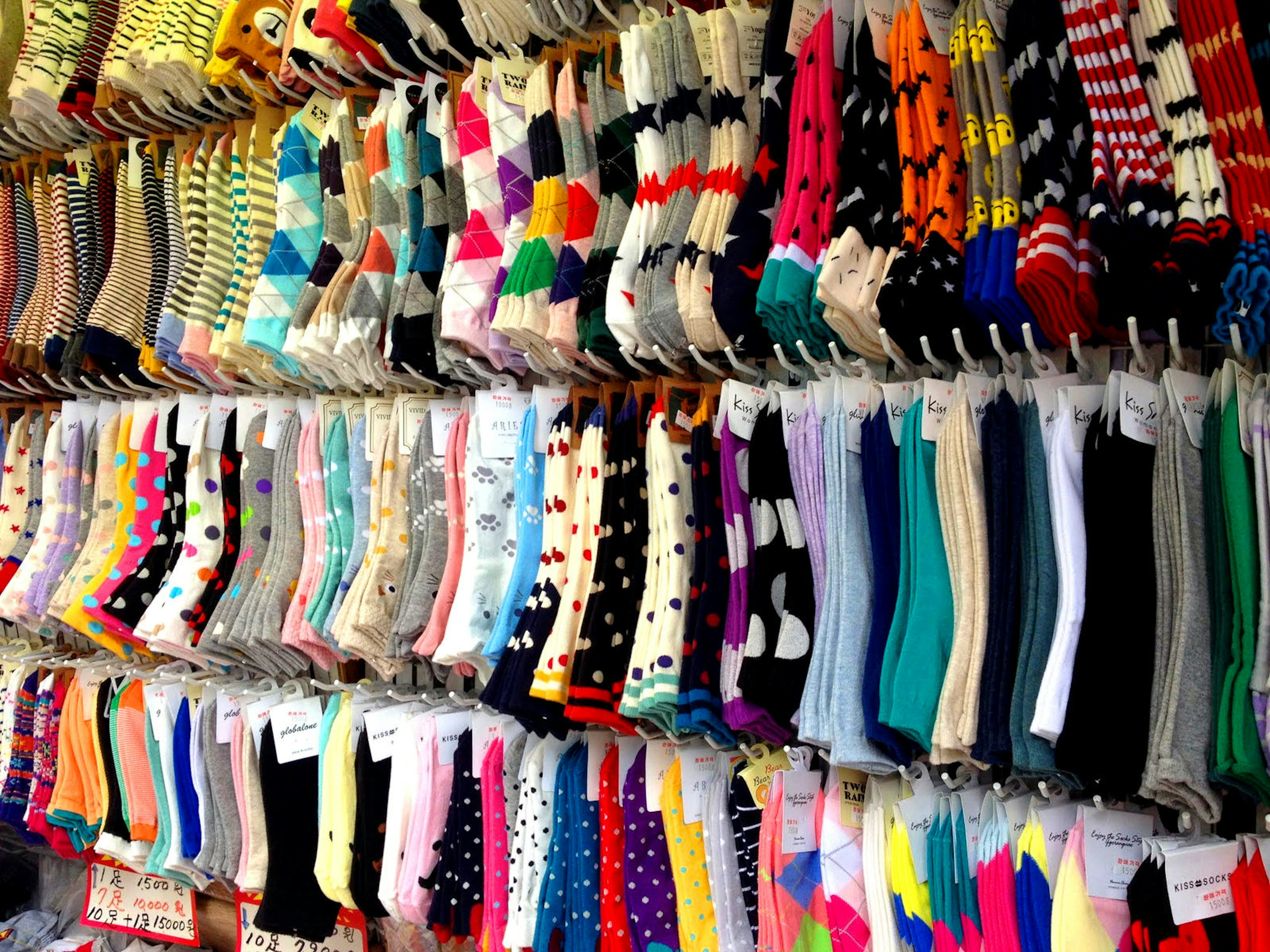 Several racks of socks in a variety of colours and patterns