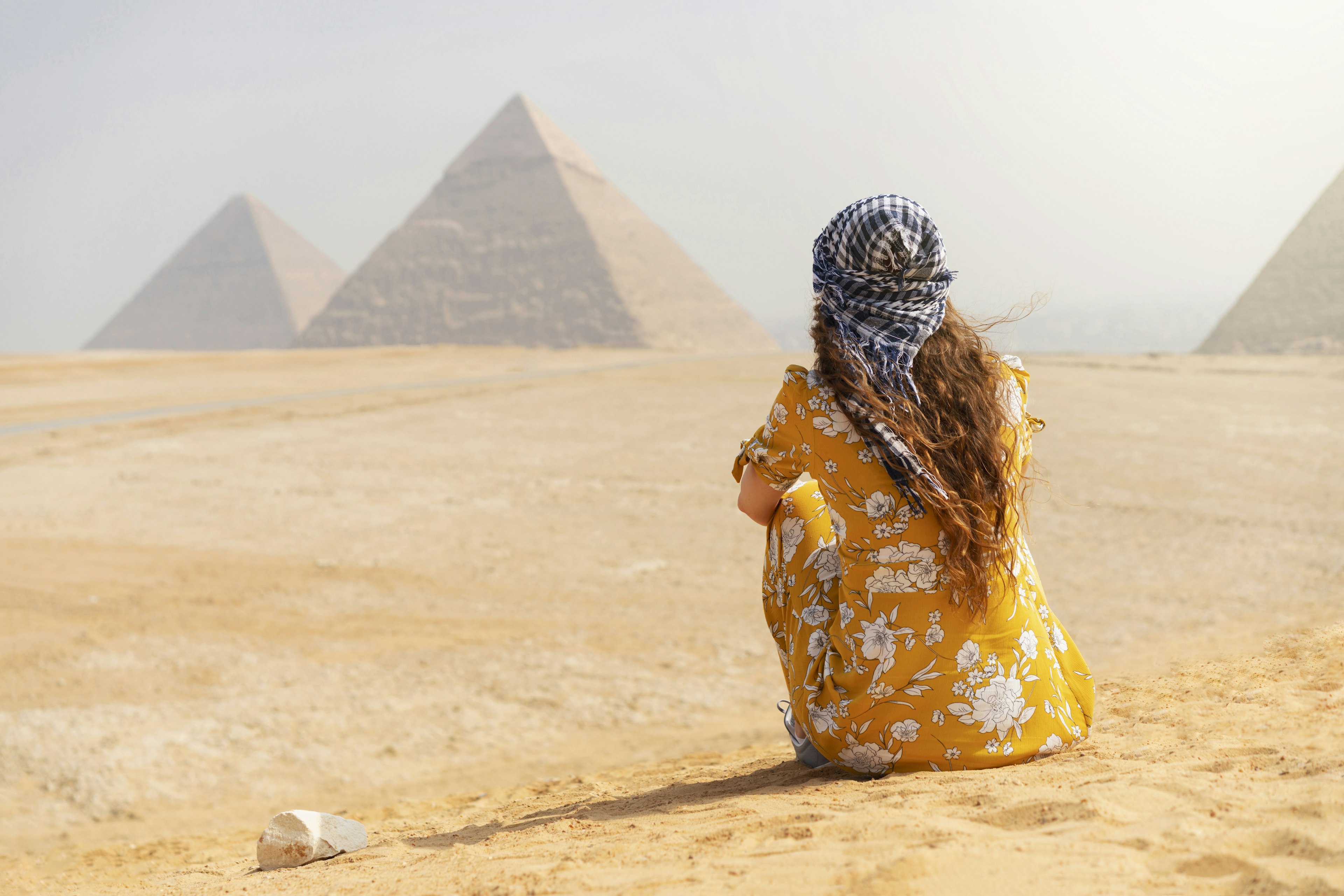 Rear view of a female tourist enjoying a tour to the Pyramids of Giza in Egypt.