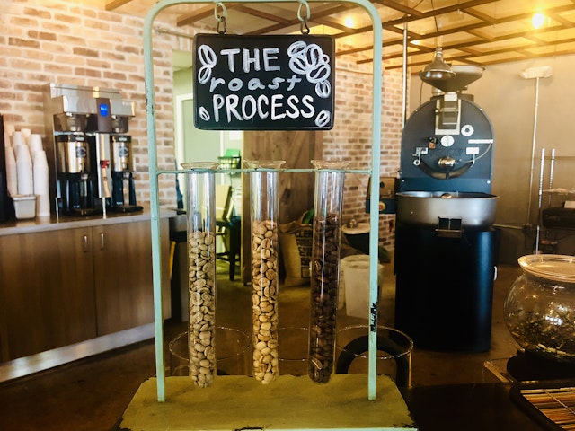 A massive roaster sits amid the bright interior of SwitchBox Coffee Roasters