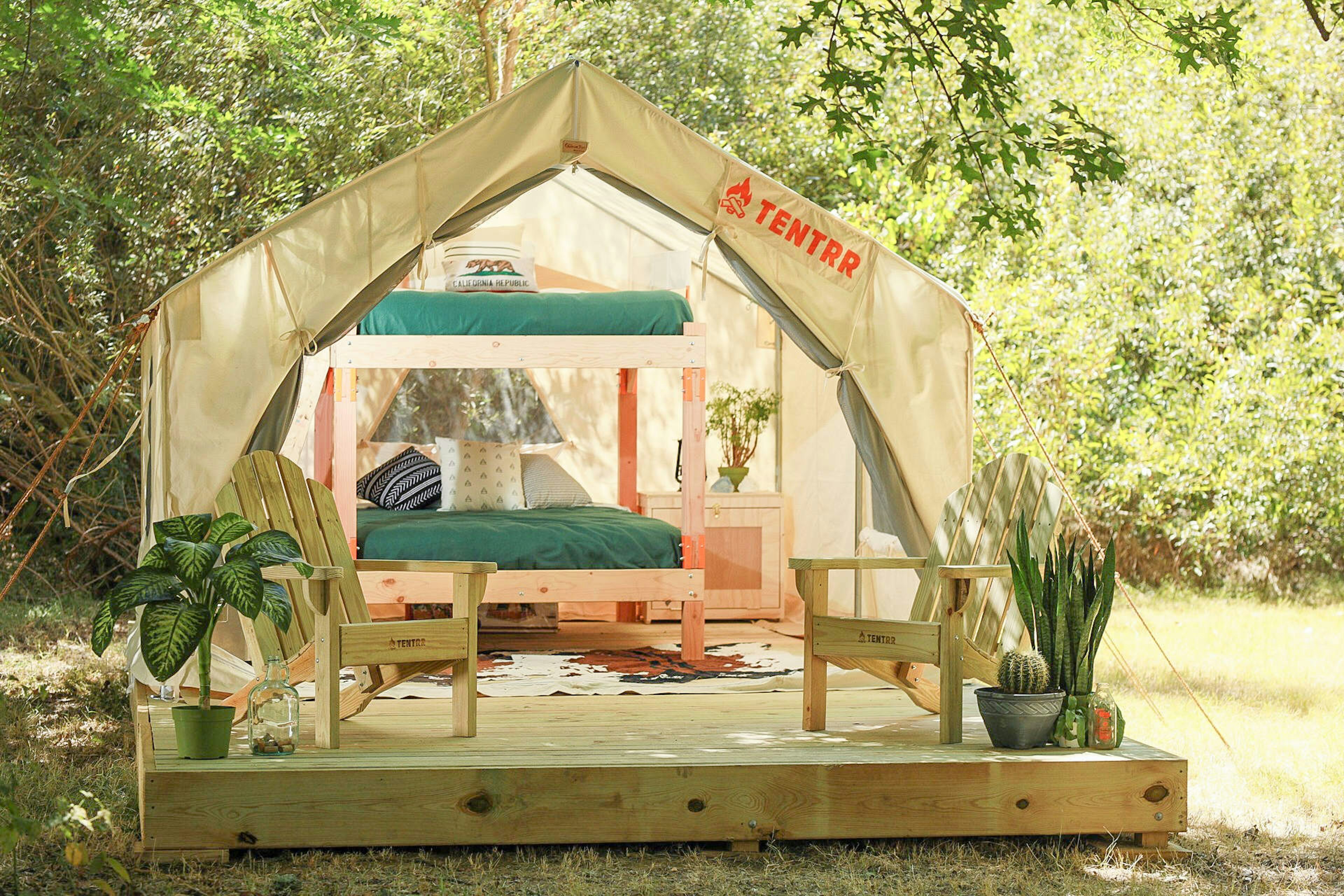 A canvas tent sits in the forest for camping.