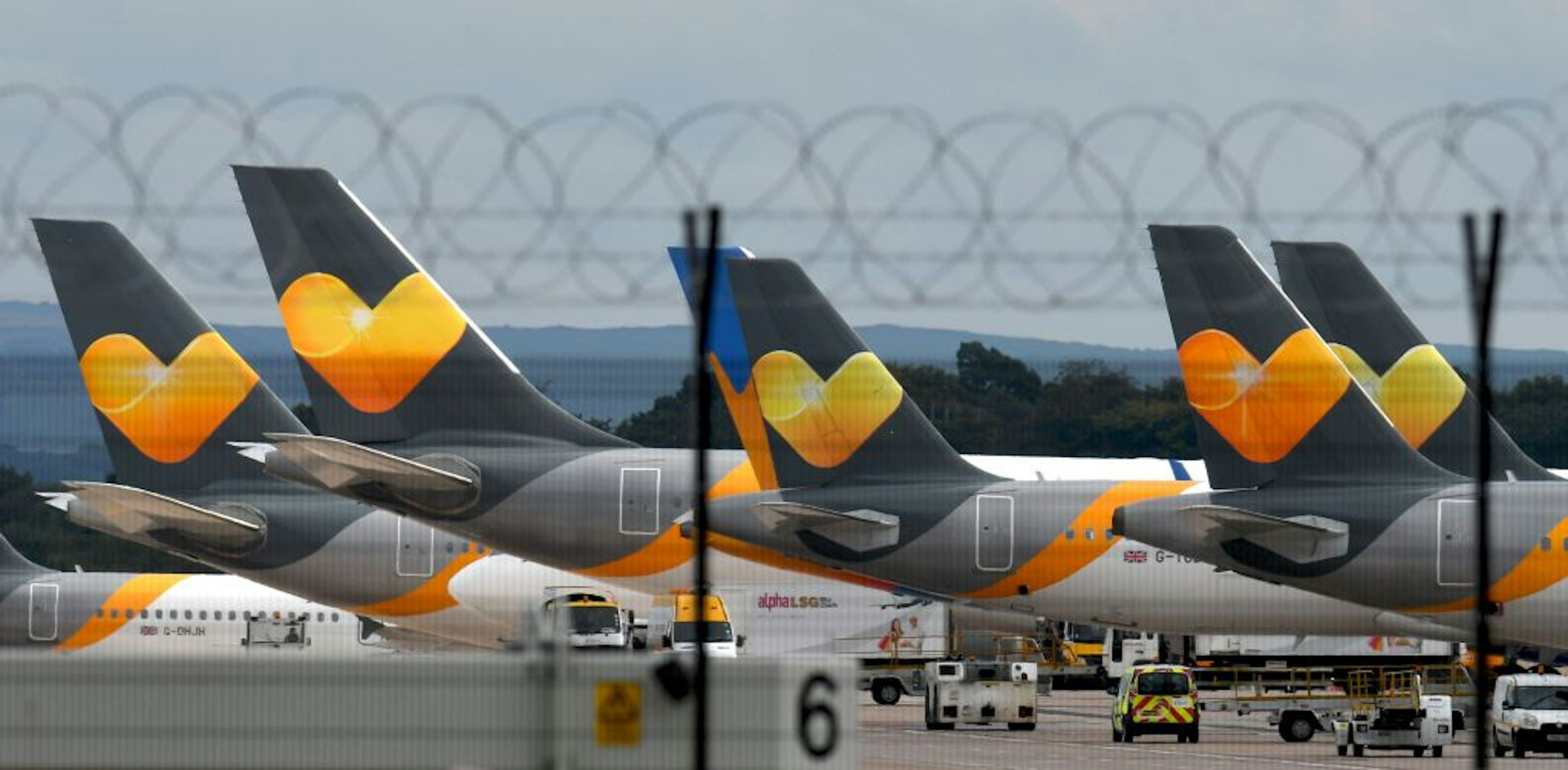 A tow of planes with orange Thomas Cook logo on the back are shown in a row.