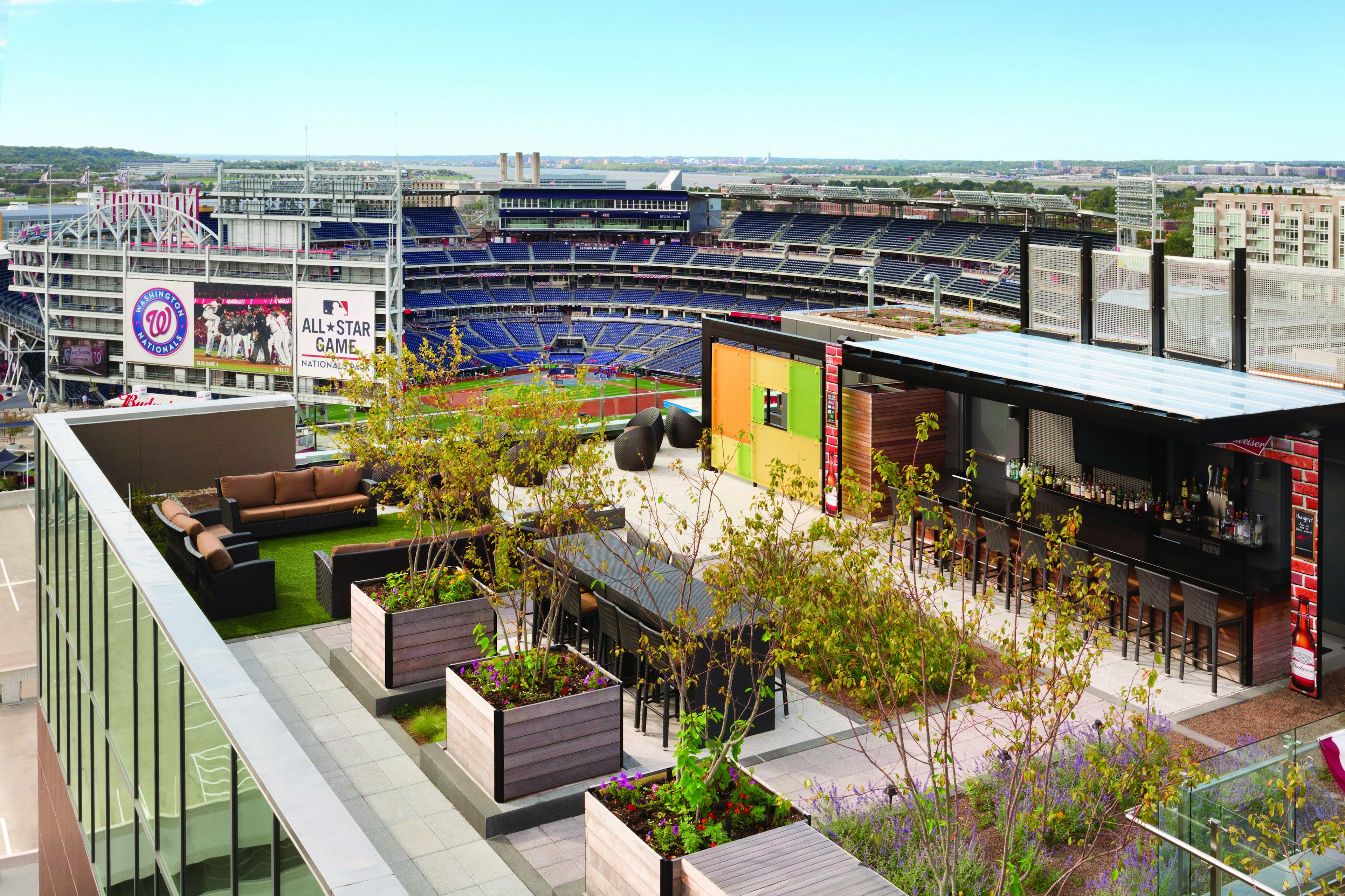 View looking down to the landscaped outdoor seating area at Top of the Yard; beyond the bar it's possible to see into the Washington Nationals' stadium.