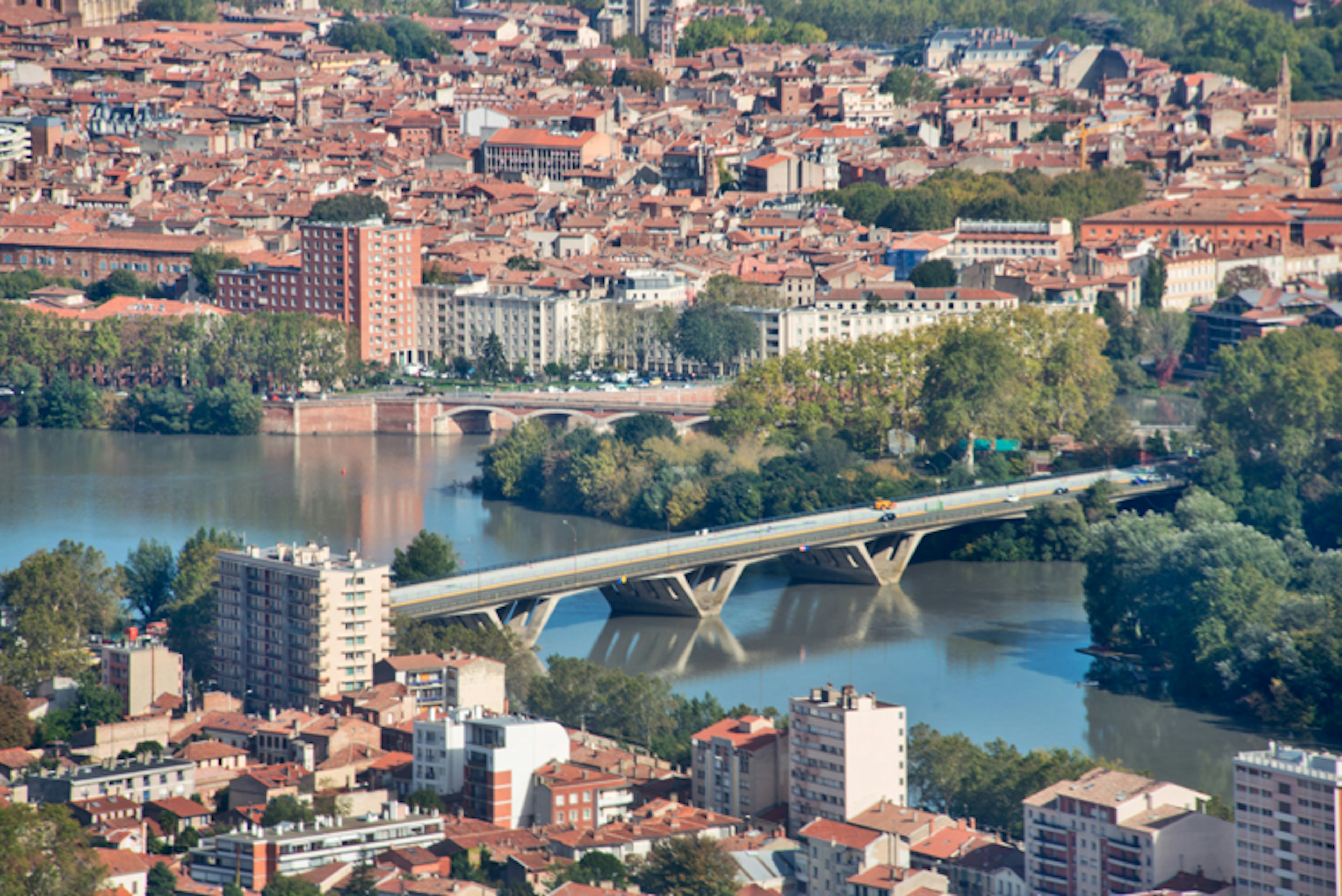 An aerial view of the Garonne river and Toulouse's peach-coloured rooftops. Image by Salvator Barki / Gallo Images / Getty Images.