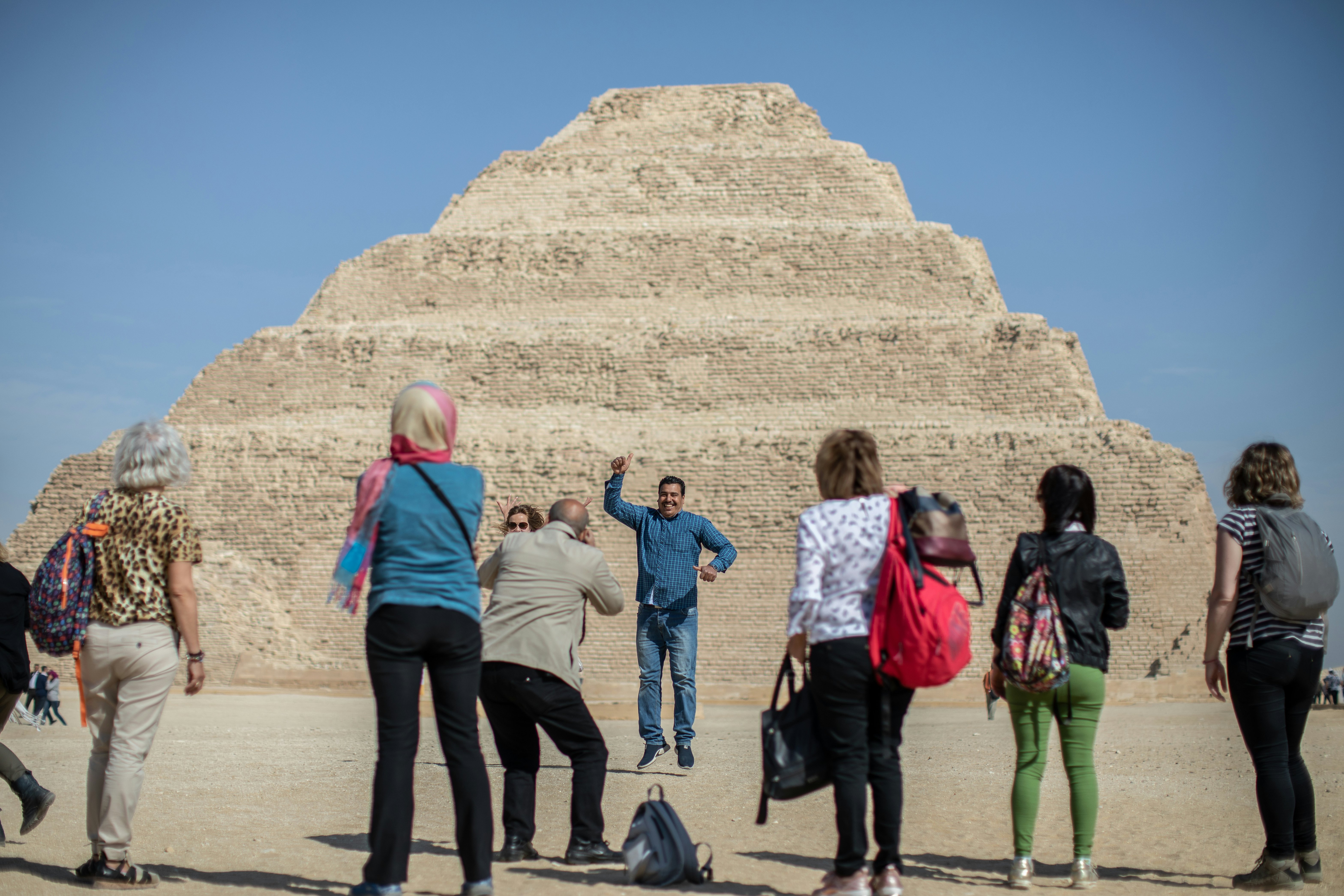 Tourists take souvenir pictures in front of the Pyramid of Djoser in Saqqara outside Cairo.