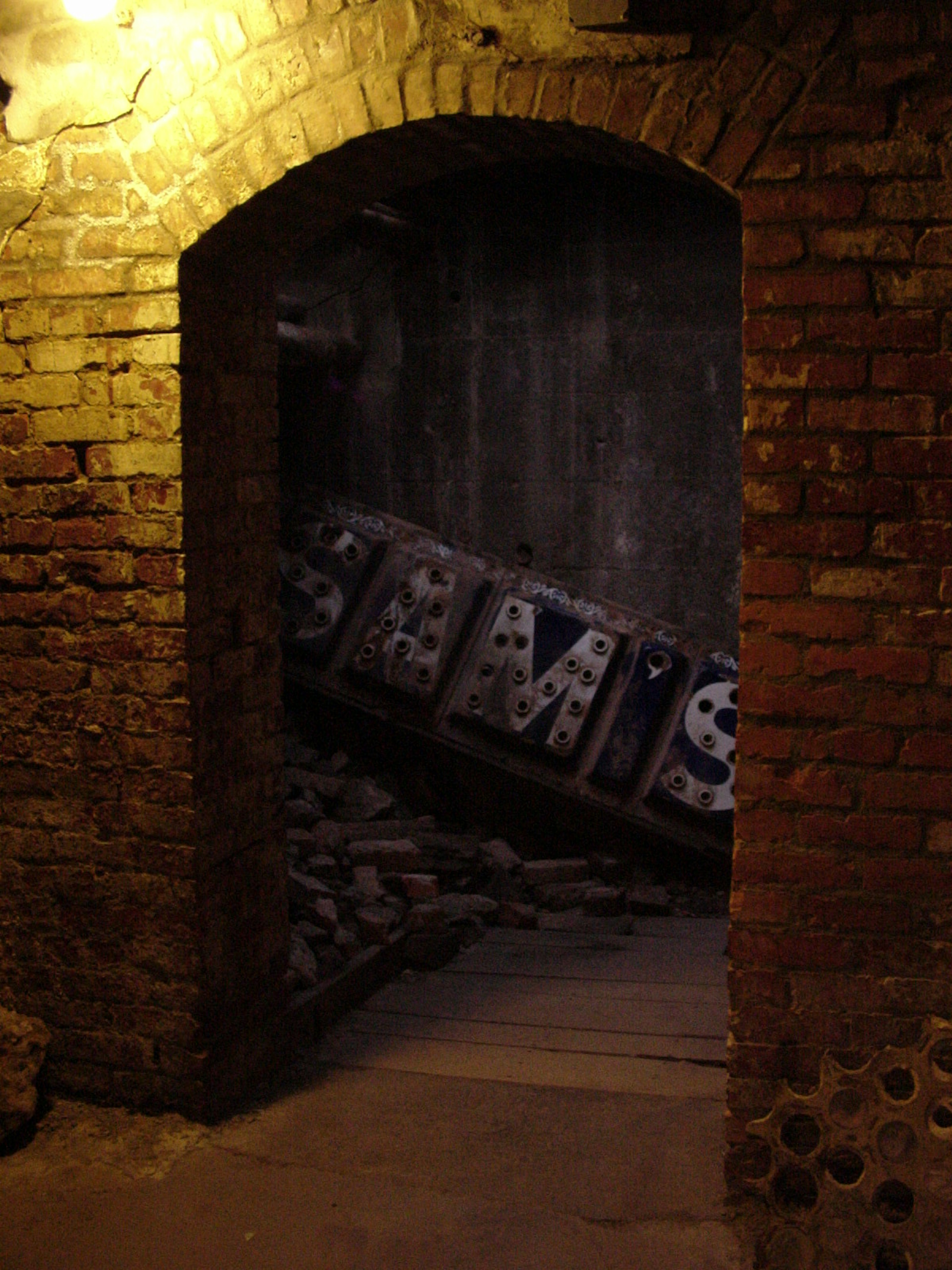 A brick archway leads to a wooden wall with an old wooden sign that says Sam's leaning nearby. Perfect weekend in Seattle