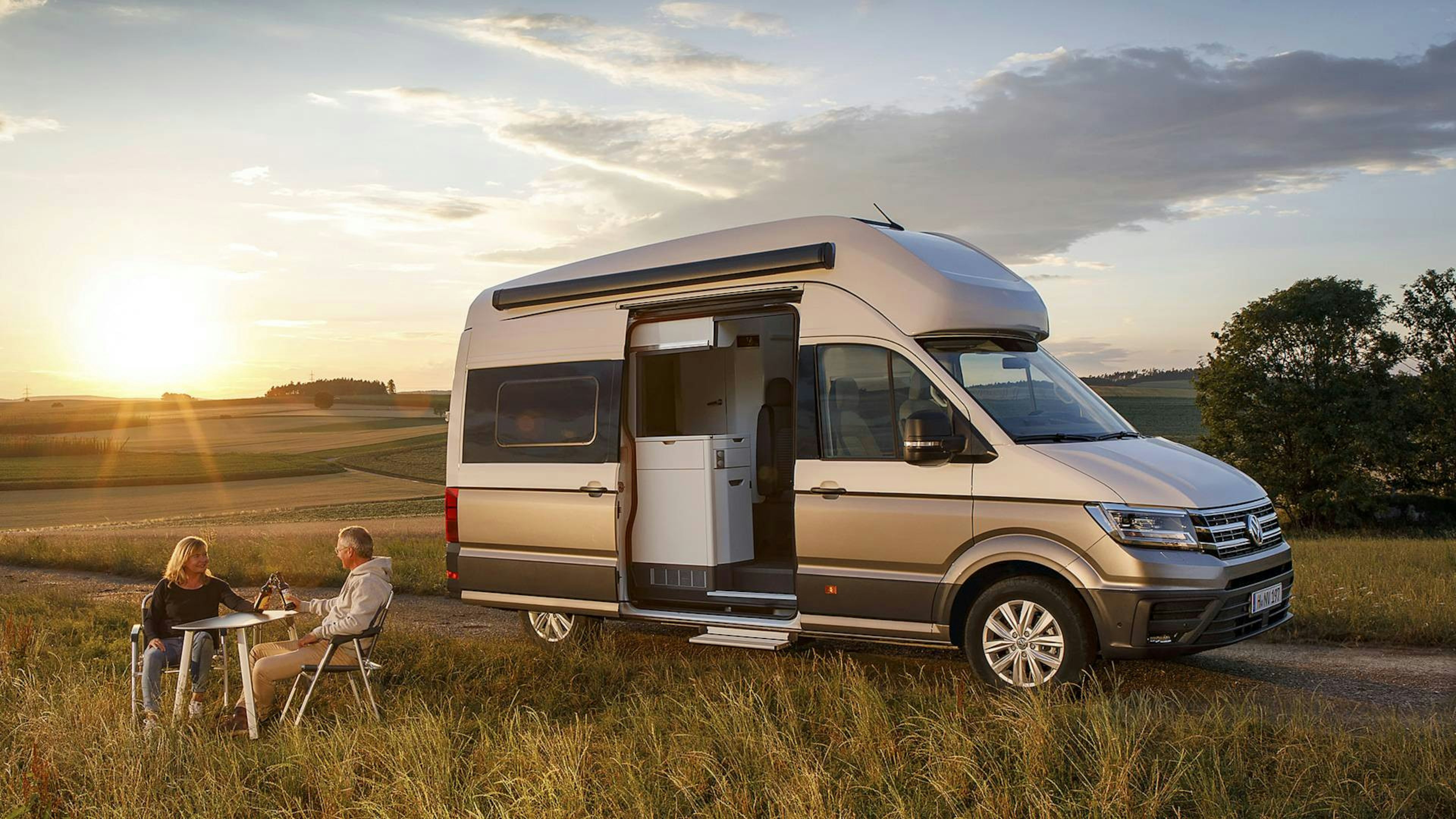 A large motorhome is parked in an open field.