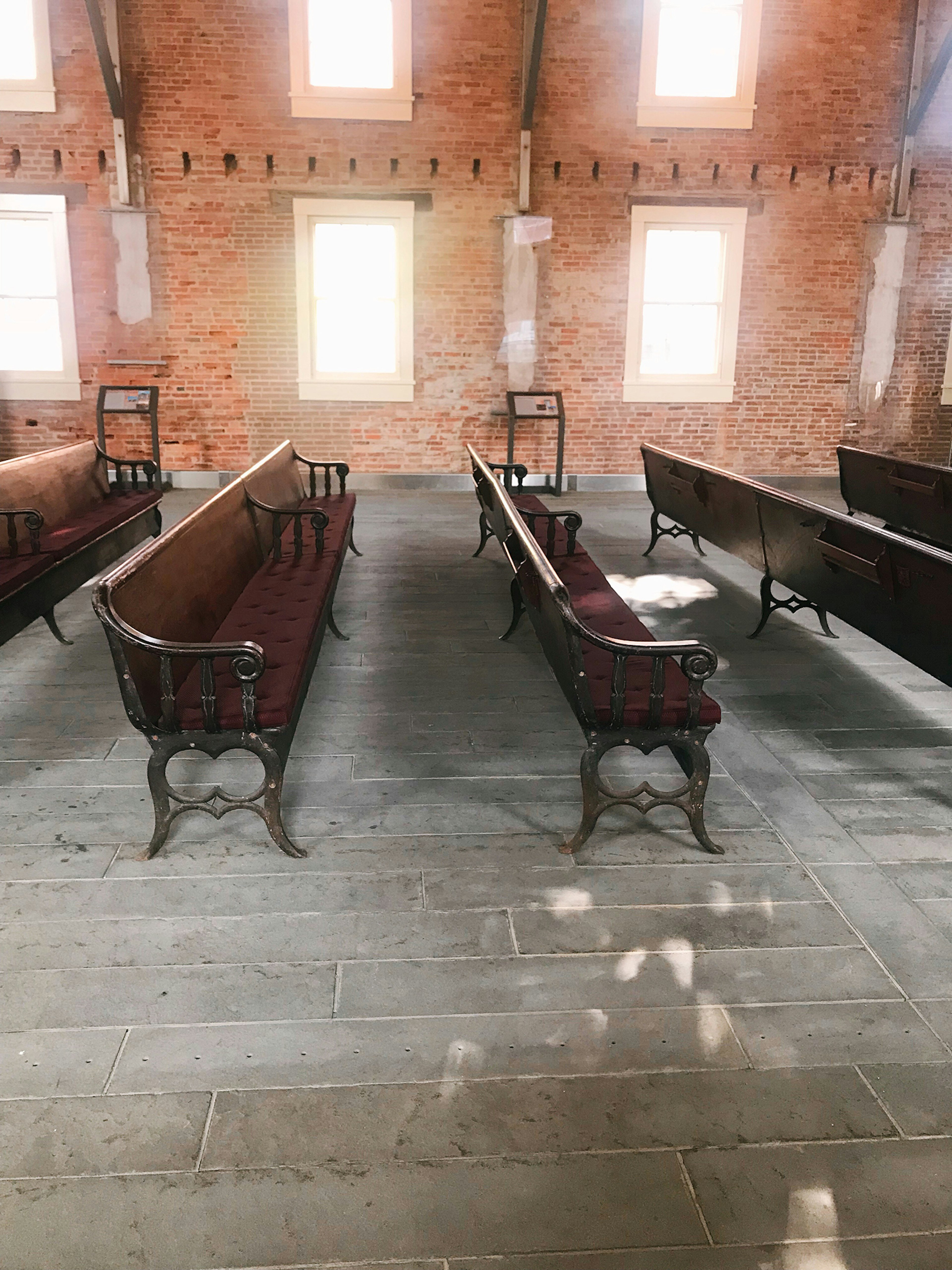 Interior of small brick chapel full of natural light and ornate original wooden pews© Mikki Brammer / Lonely Planet