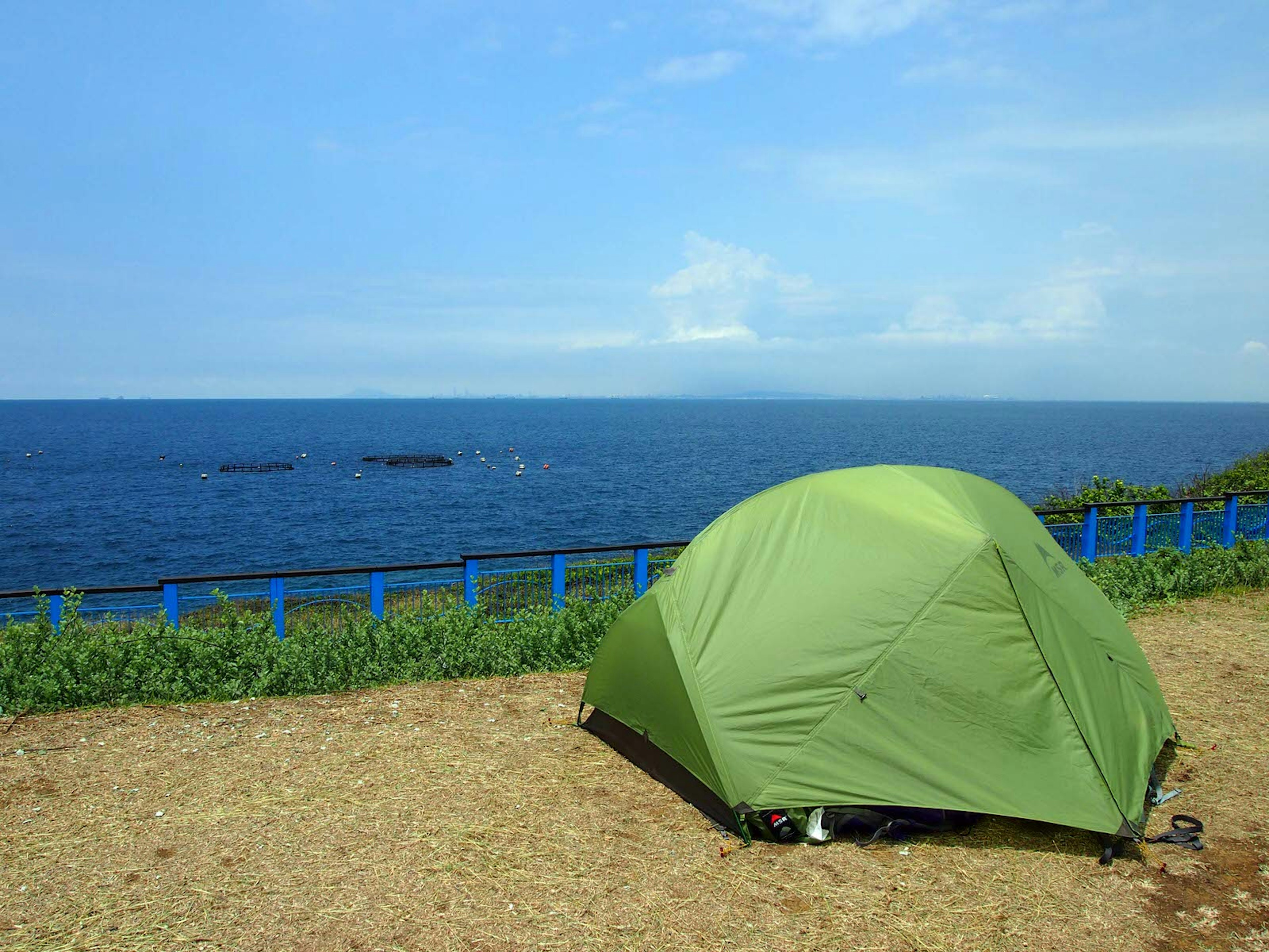 A green tent pitched on a patch of dirt overlooking the sea. Camping is popular on Little Liuchiu and offers amazing views ? Tess Humphrys / ϰϲʿ¼