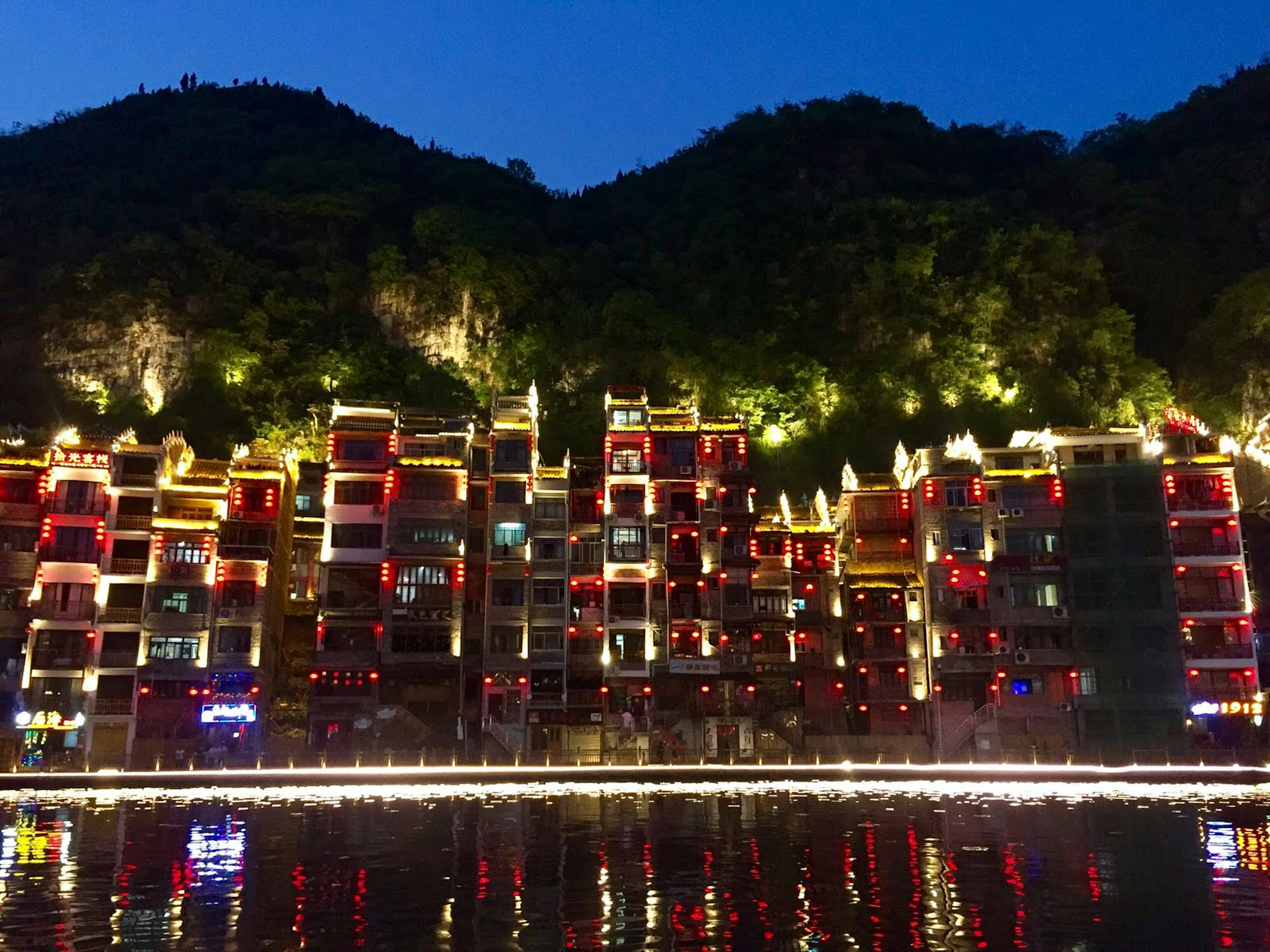 Evening lights reflected in the Wuyang River in Zhenyuan © Megan Eaves / Lonely Planet