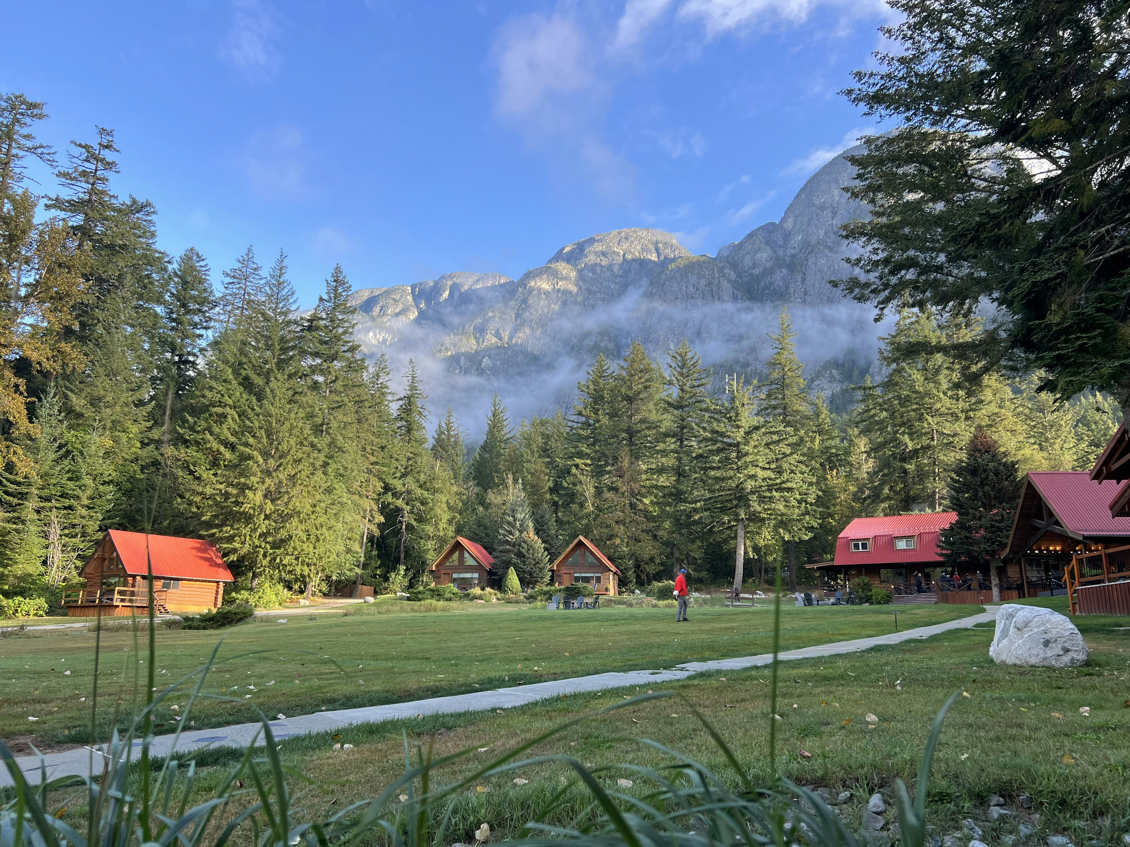 a group of cabins with rocky mountains behind Tweedsmuir