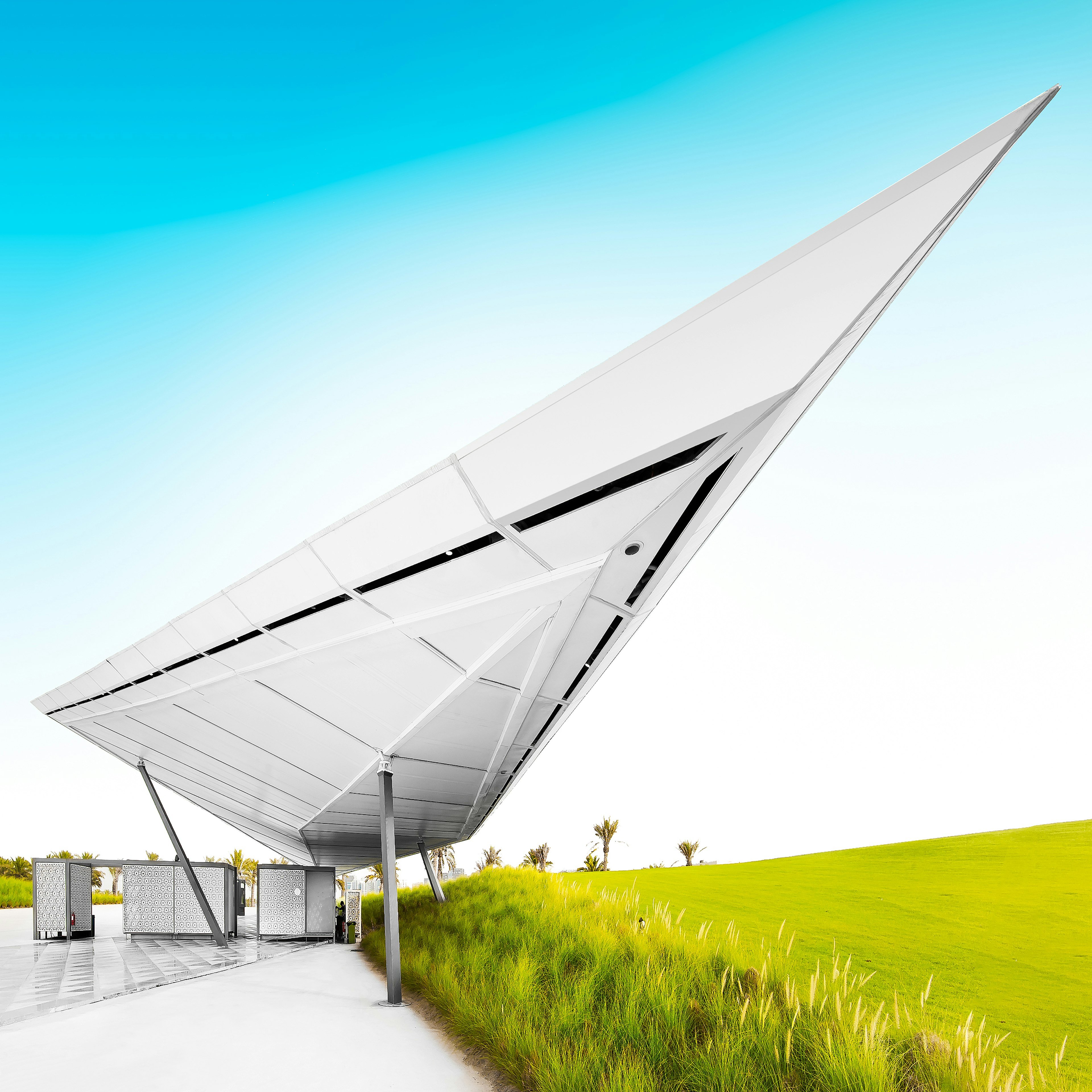 Toilet in the park of Museum of Islamic Art, Doha. A large triangle shape hangs over the middle of the image, with some green plain fields to the right.